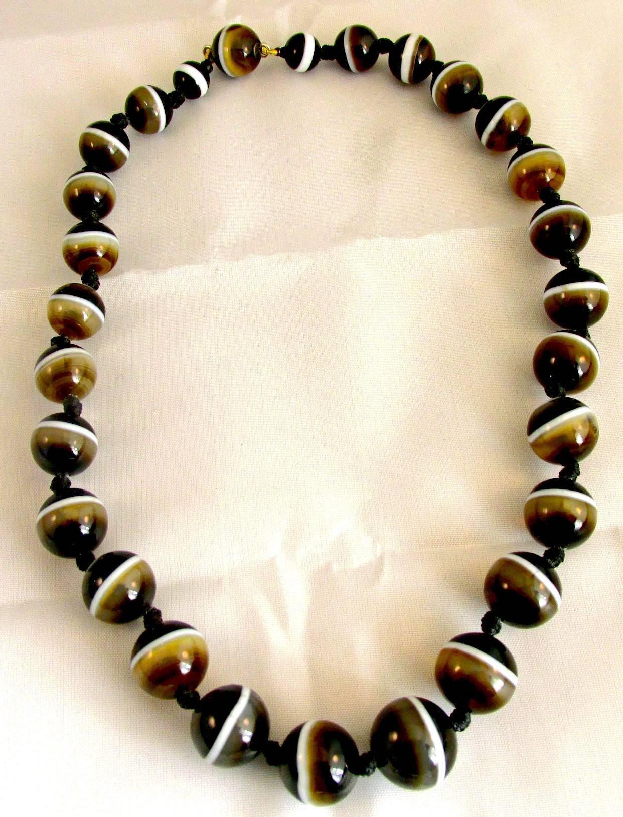 Dramatic Victorian agate bead necklace is fastened with an agate clasp. The striking banded agate beads are black, brown and white and can be worn day or night. The necklace measures 17