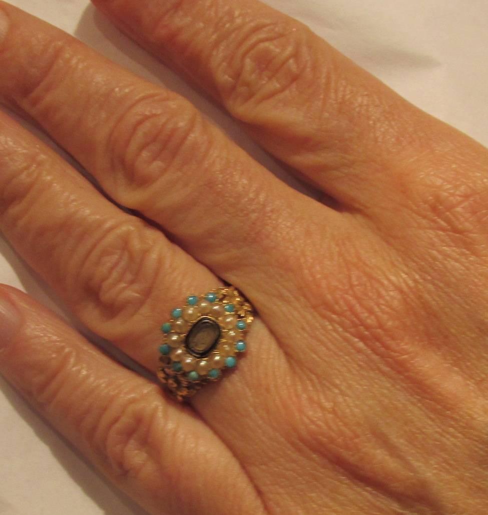 Georgian memorial ring in 18K gold with pearls and turquoise in an ornate chased setting. The lock of hair surrounded by black enamel was for the remembrance of a loved one departed. The ring is hallmarked London 1833 and is a size 7 1/2.