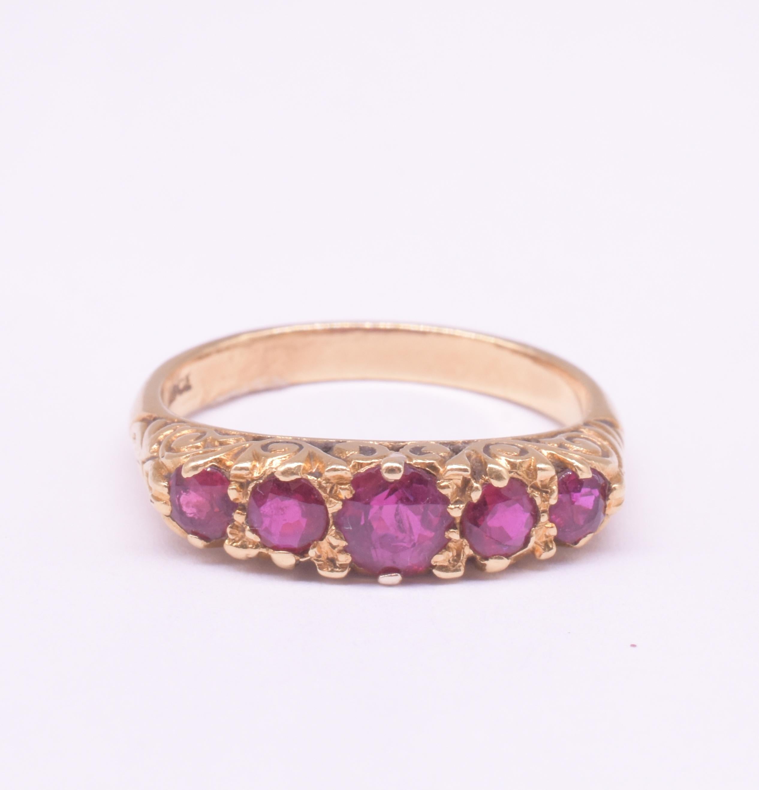 Cette bague édouardienne en or 18 carats (estampillée et testée) à cinq pierres en rubis, également connue sous le nom de bague à cinq pierres à demi-arceau, est sertie au jour le jour, sans feuille et avec un dos ouvert pour refléter la lumière.