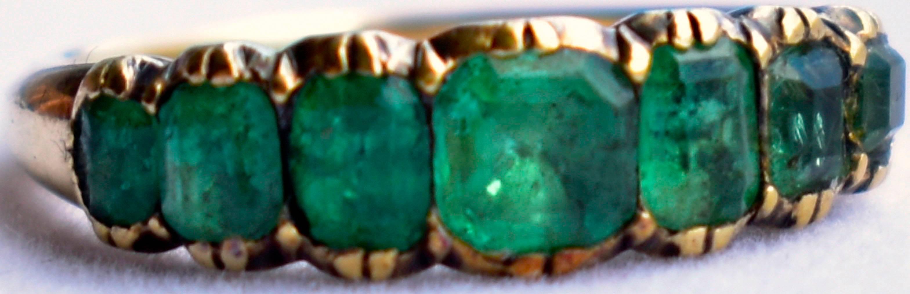 Lovely Georgian seven stone emerald ring set in 18K gold. Wonderful to wear alone or stacked with other stone band rings. This ring dates to c. 1800 and is a size 7.