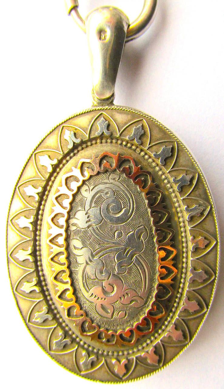 Fanciful Victorian silver collar with a silver locket embellished with two-color gold. The necklace and locket are adorned with geometric arch motifs and engravings. The necklace measures 16 1/2