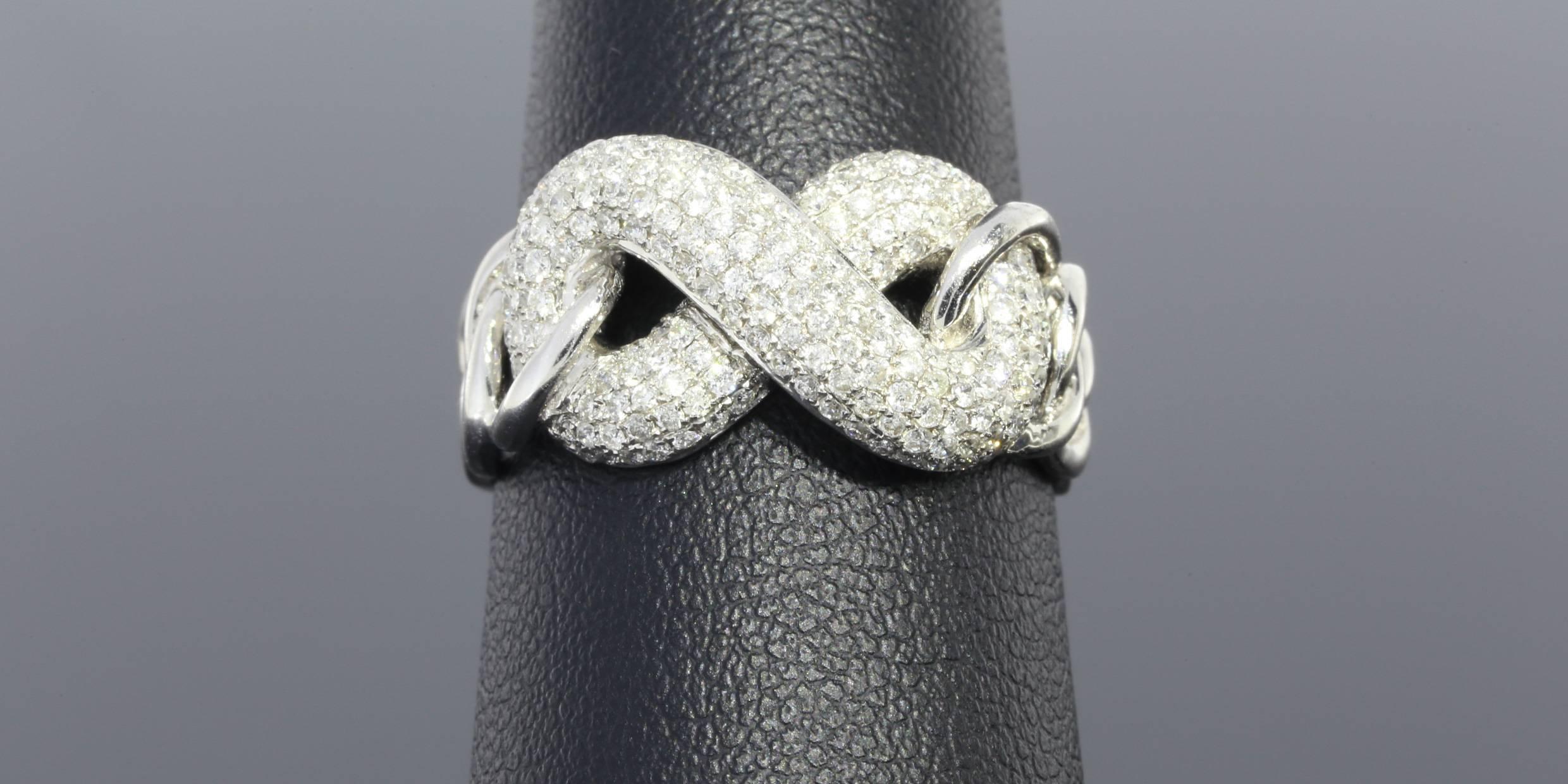 This amazing ring is sparkly, beautiful, & quite unique! The ring features round brilliant cut diamonds that have a combined total weight of 1 carat. These diamonds are pave set in an infinity love knot in the center of an 18 karat white gold ring.