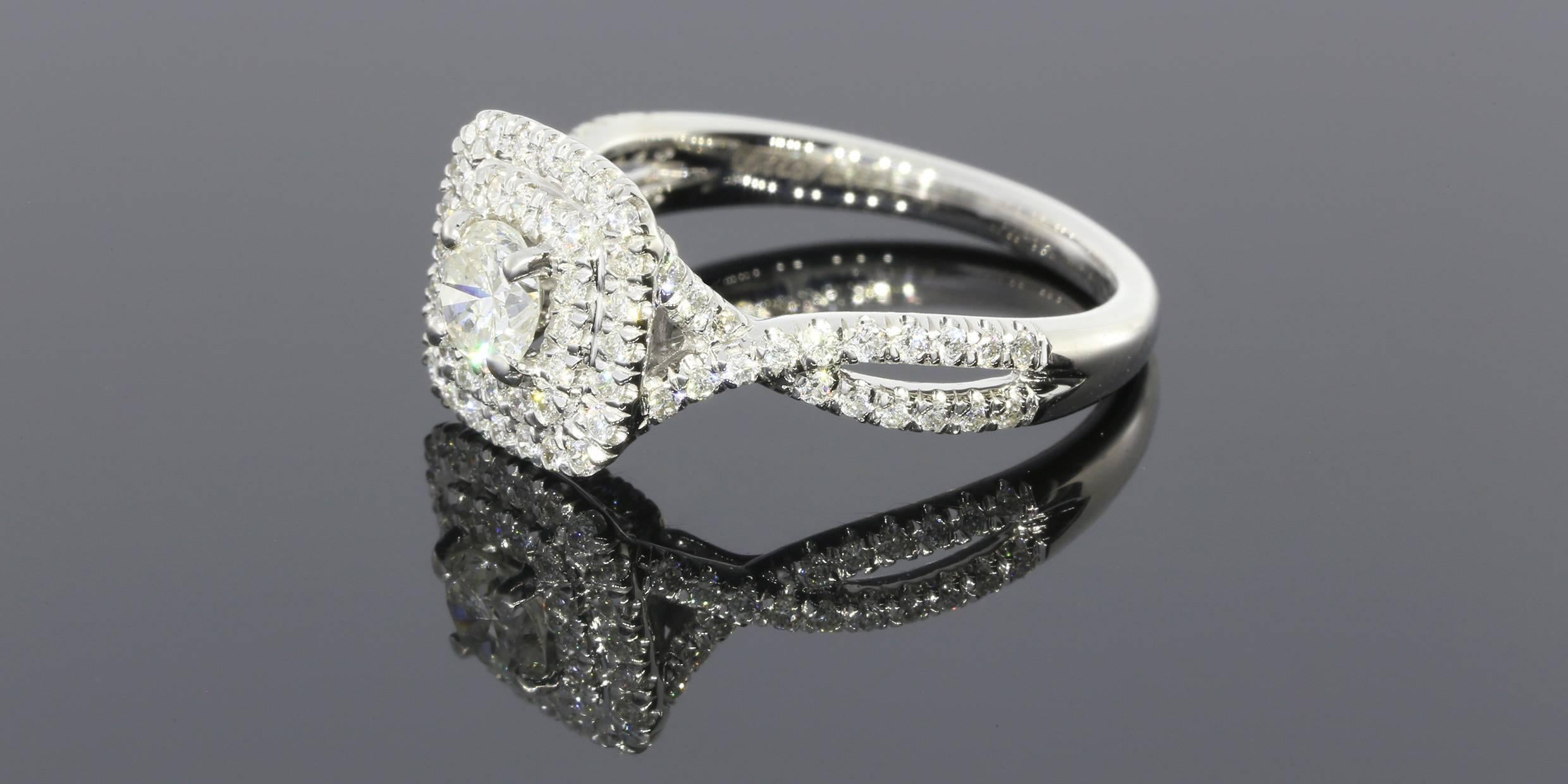 Dieser beeindruckende Ring enthält einen runden Brillanten mit einem Gewicht von 0::36 Karat:: J/I1. Der Ring enthält außerdem runde Diamanten im Brillantschliff mit einem Gewicht von 0::49 ctw. Die Diamanten sind in Zacken gefasst und bilden einen