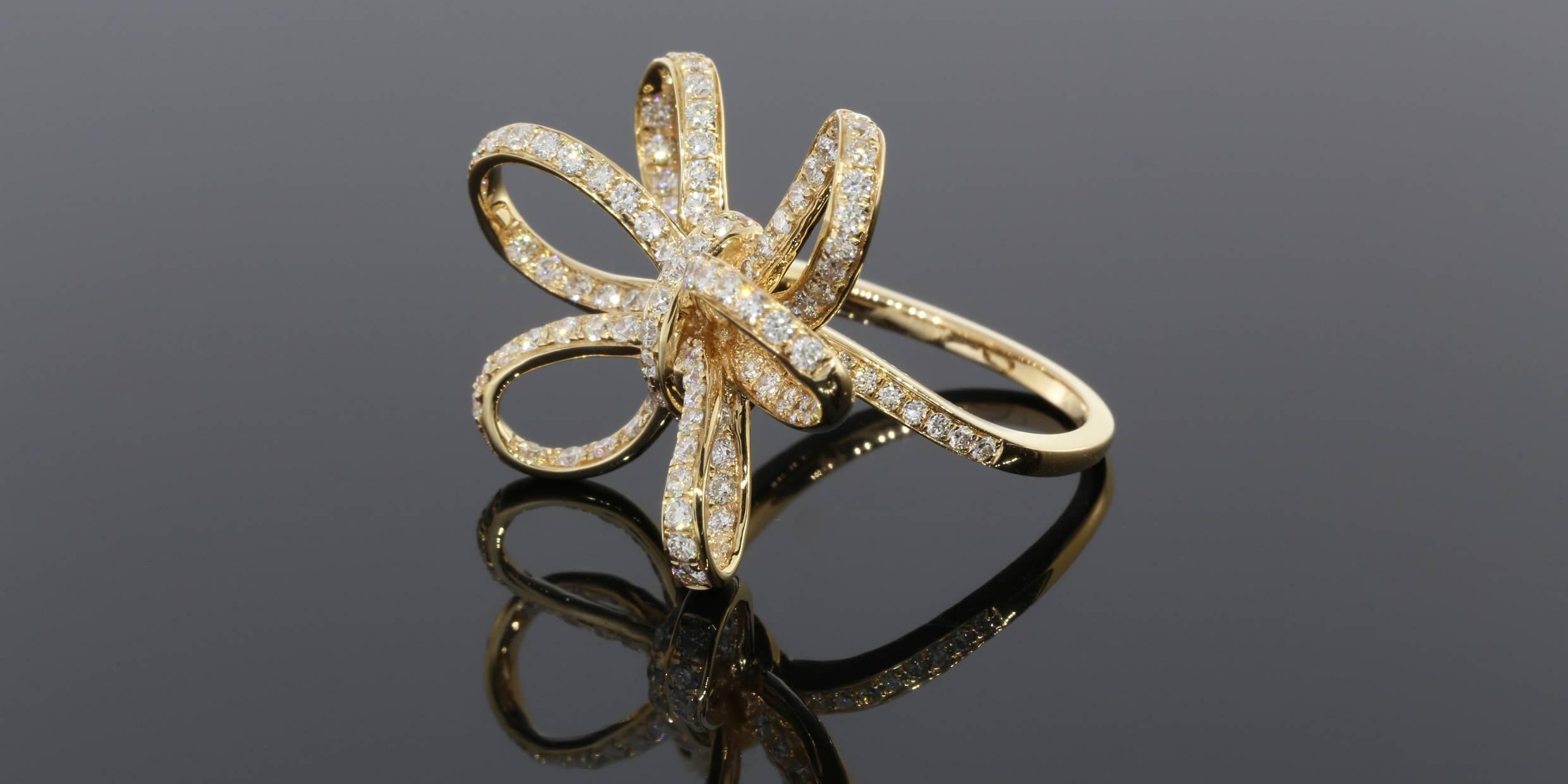 This bow ring is fun accessory that makes the perfect right hand ring to dress up any outfit. The ring is designed to look like a six loop bow studded with diamonds. It has approximately 127 round brilliant prong set diamonds with a total carat