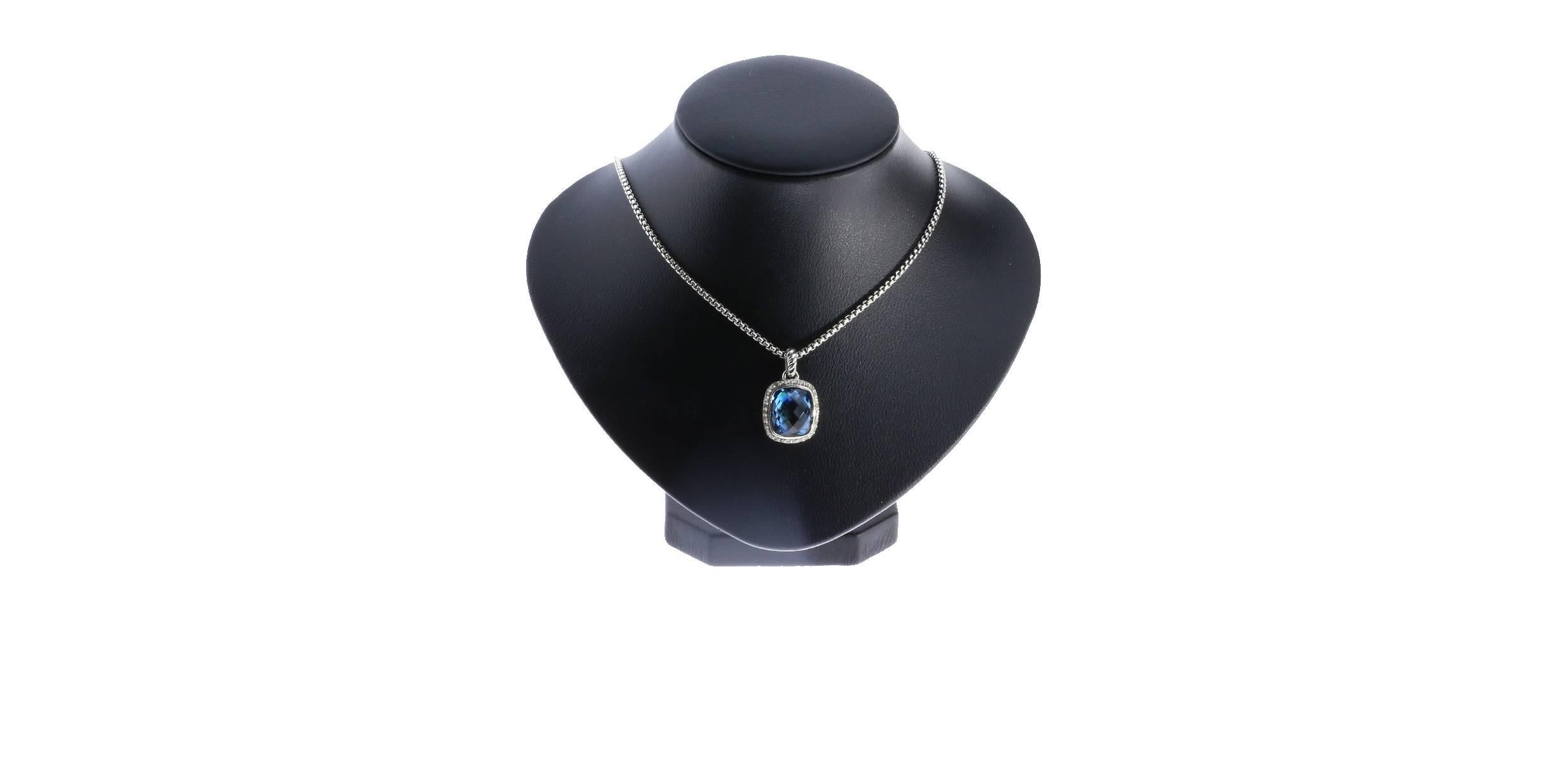 This pendant necklace is from the Noblesse collection by David Yurman. The center stone is a gorgeous, checkerboard faceted, cushion cut blue topaz that is surrounded by a halo of diamonds with a total weight of .25 carat. The bail has a touch of