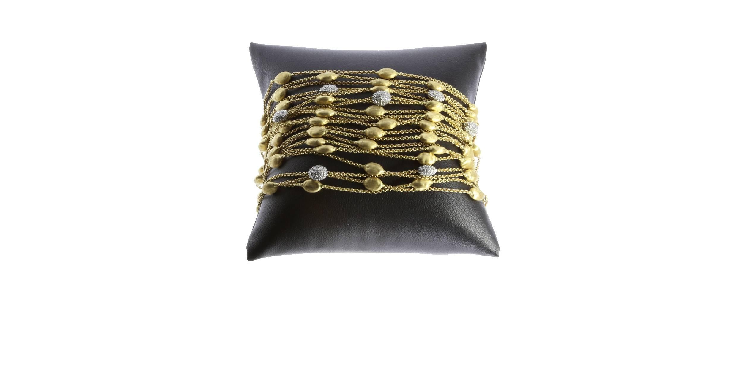 Your look will get a dramatic touch with this Marco Bicego 18 karat yellow gold 20 strand diamond bracelet from the Siviglia collection. Twenty gold strands of link bracelet are showered with yellow gold oval shapes that sport the textured finish of