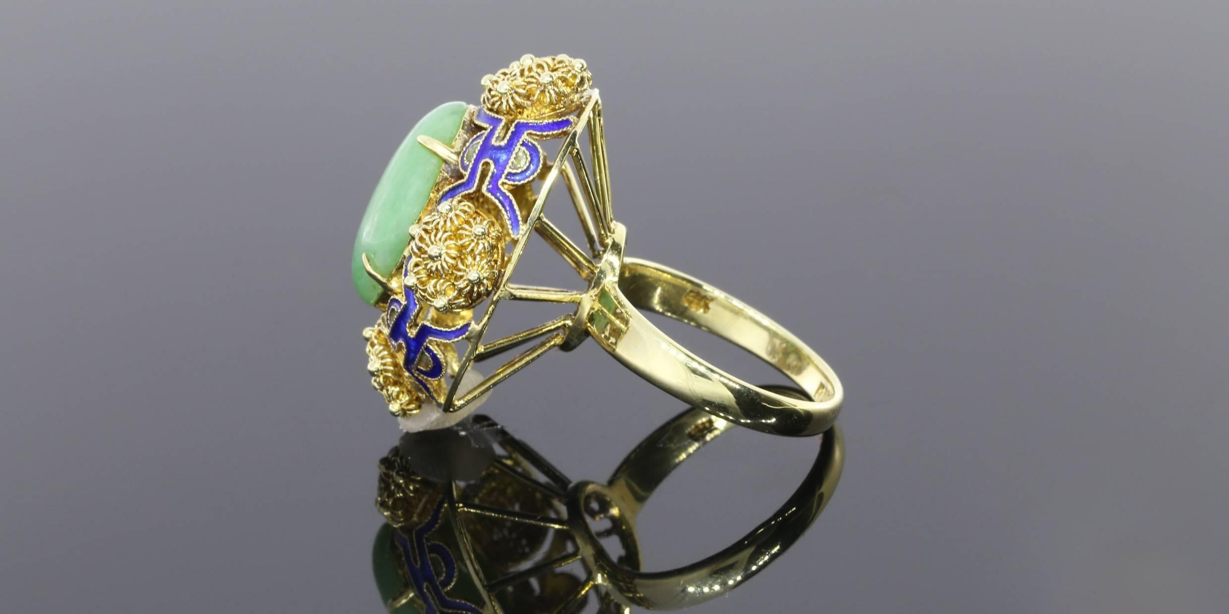 This is a beautiful, vintage jade and blue enamel flower ring. The ring features one jade oval cabochon stone measuring approximately 15 millimeters by 9 millimeters (.59 inches by .35 inches). This jade is a lovely medium green color, not too dark