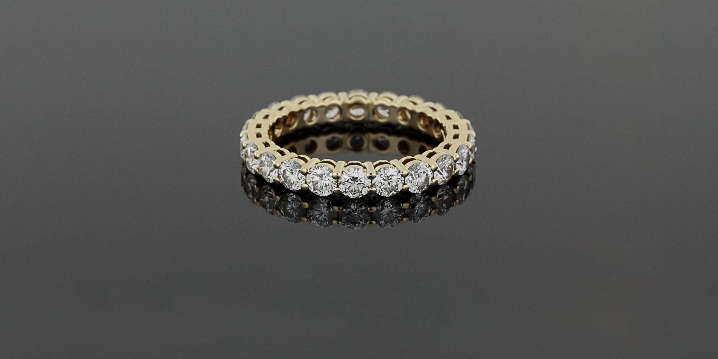 This gorgeous, classic band is from Tiffany & Co. It features 22 round brilliant cut diamonds that have a combined total weight of 1.76 carat & grade as G/VS2-SI1 in quality. The diamonds are shared prong set in a beautiful 18 karat yellow gold