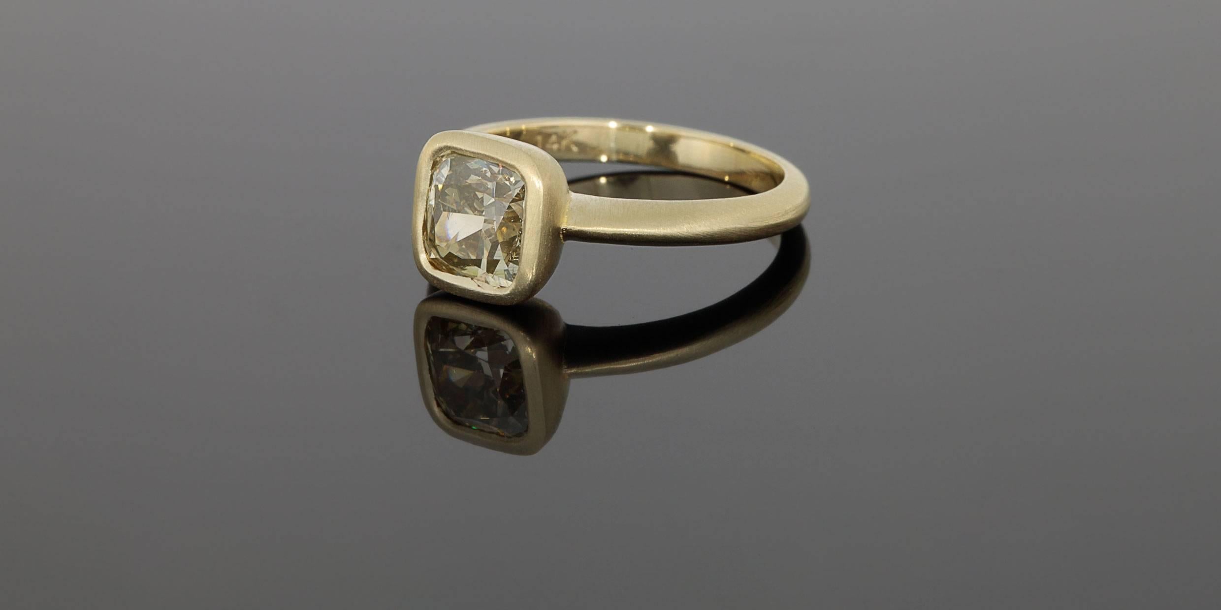 This gorgeous ring features a stunning 1.72 carat fancy yellow, cushion brilliant cut center diamond. This diamond is GIA certified to have natural, even, fancy color. It is a beautiful champagne yellow color, & the diamond is very well cut. The
