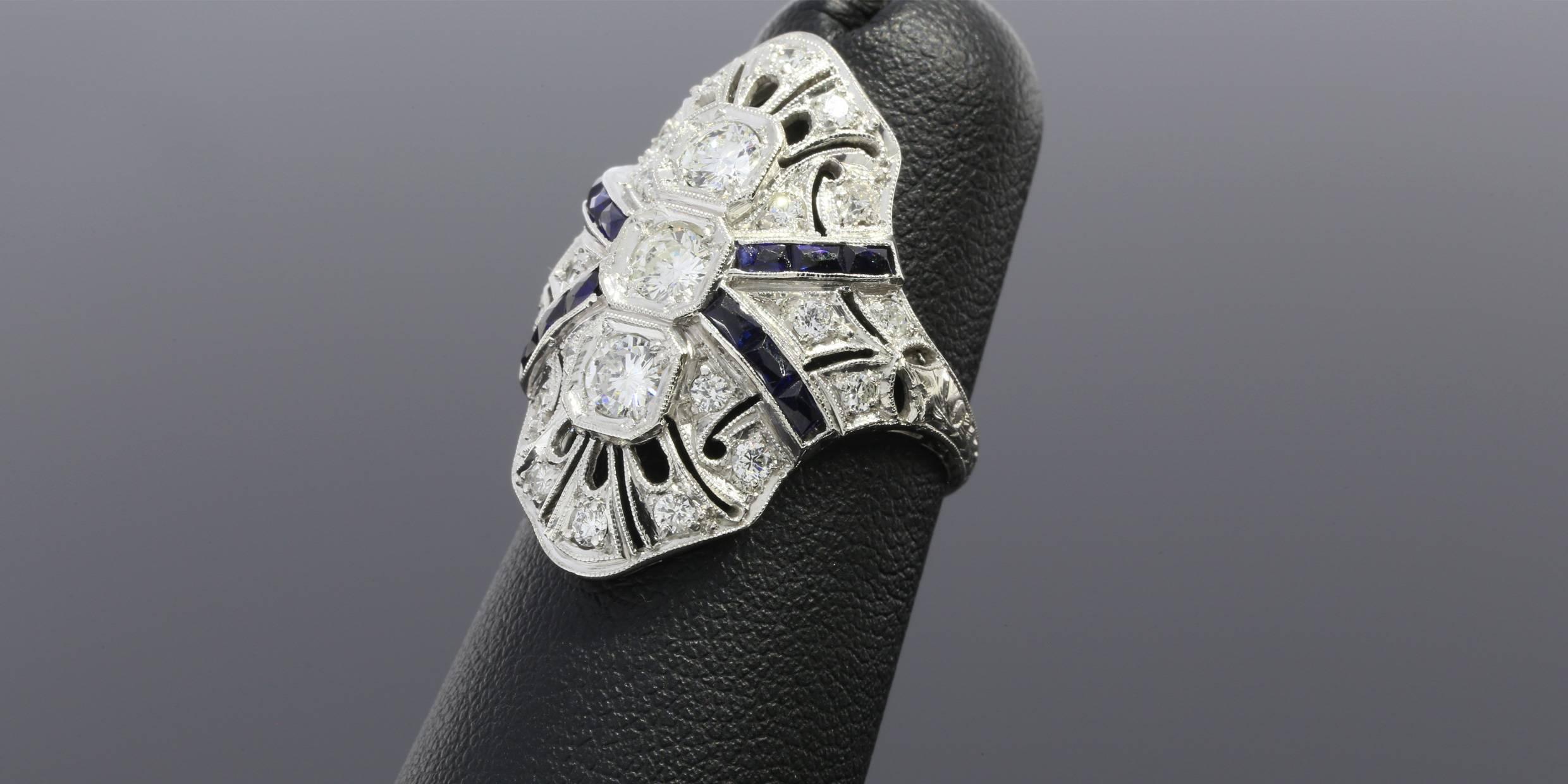 This gorgeous diamond ring features shimmering round brilliant cut diamonds & rectangular faceted blue sapphires with a combined total weight of approximately 1.5 carats. The diamonds are GH/SI in quality & bead set in an art deco style,