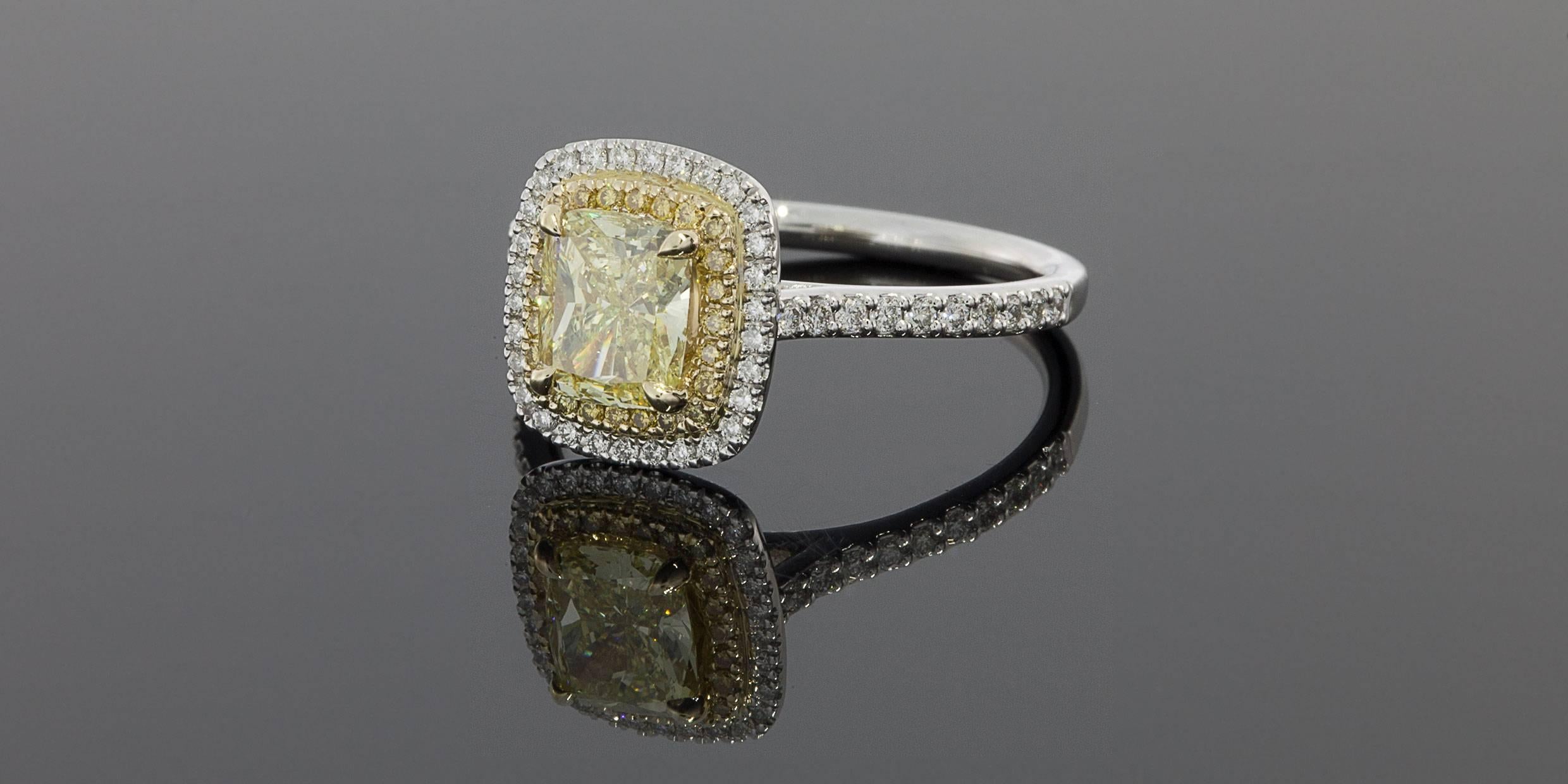 This gorgeous halo engagement ring features a stunning 1.0 carat canary yellow, rectangular, cushion modified brilliant cut center diamond that is set in a yellow gold head on a white gold custom made ring. This stunning center diamond is GIA