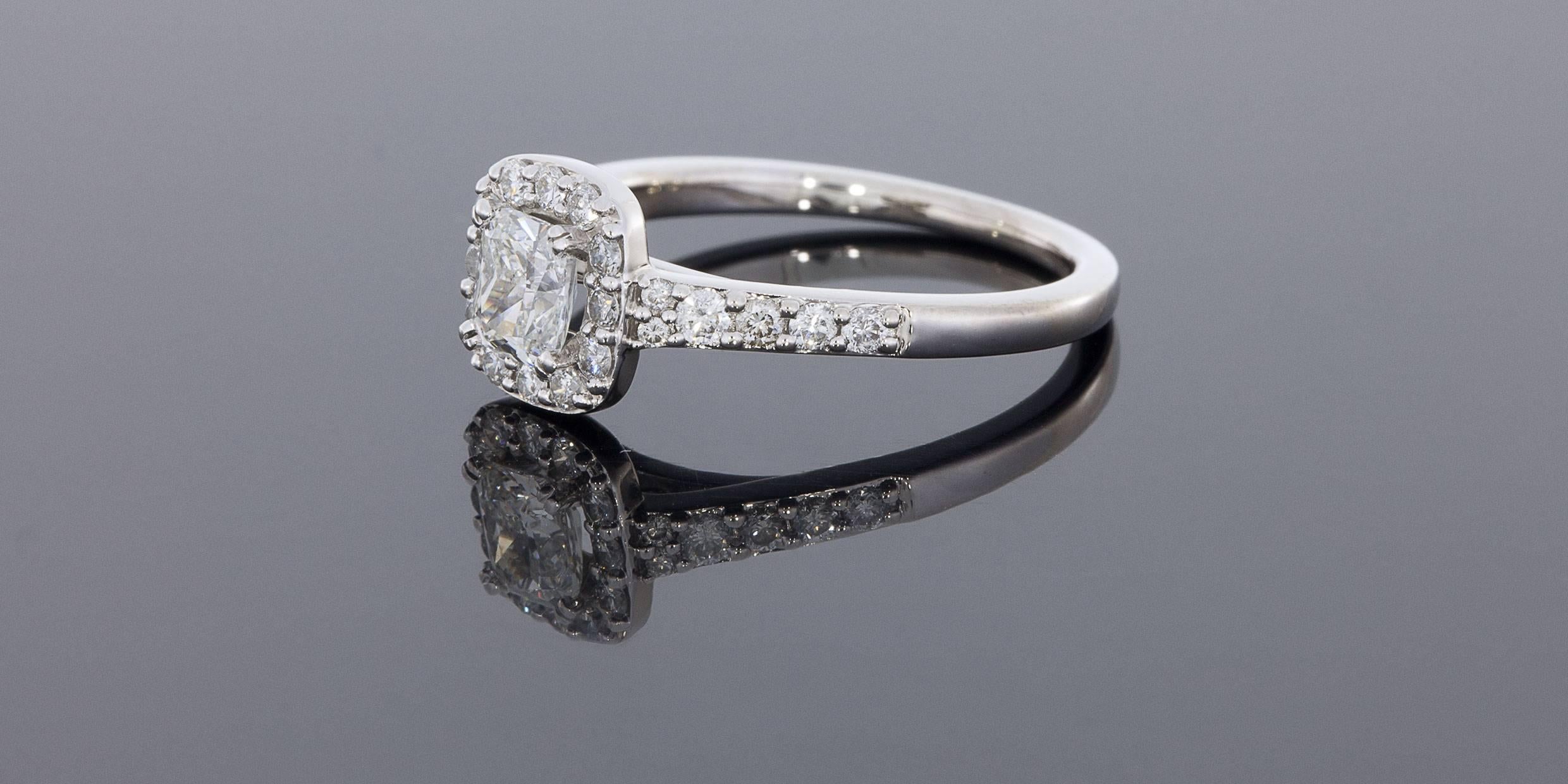 This gorgeous white gold diamond ring features a beautiful cushion brilliant cut center diamond with lots of sparkle! This center diamond weighs 1/2 carat & grades as I/SI2 in quality. It is split prong set in a shared prong diamond halo. The