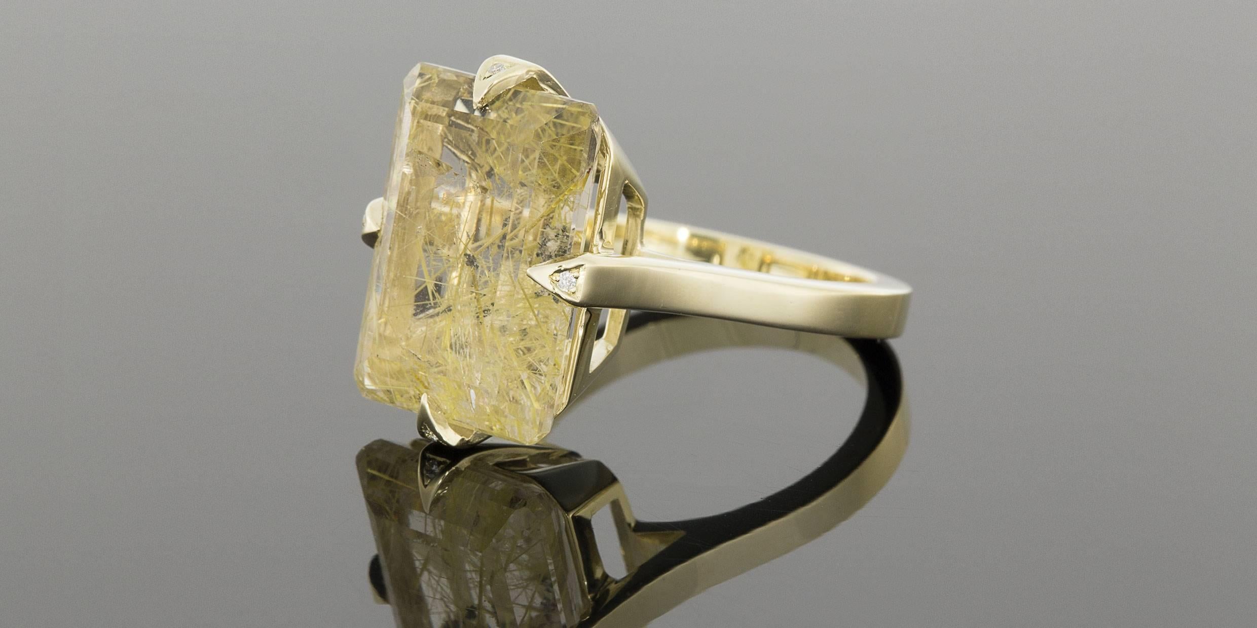 This stunning ring was custom created specifically for this 11.30 carat, emerald cut rutilated quartz. Radiant & warm with its beautiful shades of yellow & gold, this ring is comprised of 10 karat yellow gold & features diamond prongs. The shank