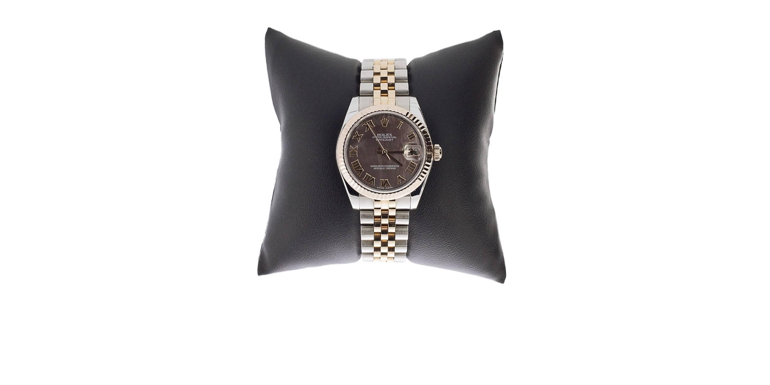 This stunning midsize Rolex Datejust is simply amazing! This watch has a factory Rolex, black mother-of-pearl, Roman numeral dial with beautiful colors. The bezel is a fluted, fixed, Everose Gold (18 karat rose gold) bezel. The watch features a 31mm