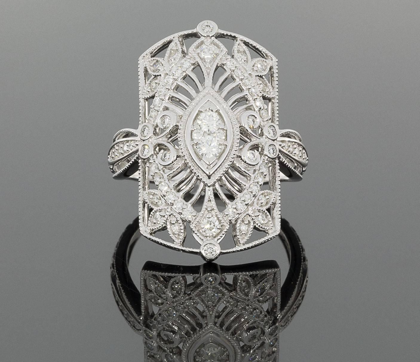 This stunning ring is a beautiful vintage style ring with lovely open filigree work, scrolls, leaf shapes, & milgrain accents. The ring is comprised of 18 karat white gold & features .52 carat total weight in sparkly diamonds. The center of the ring
