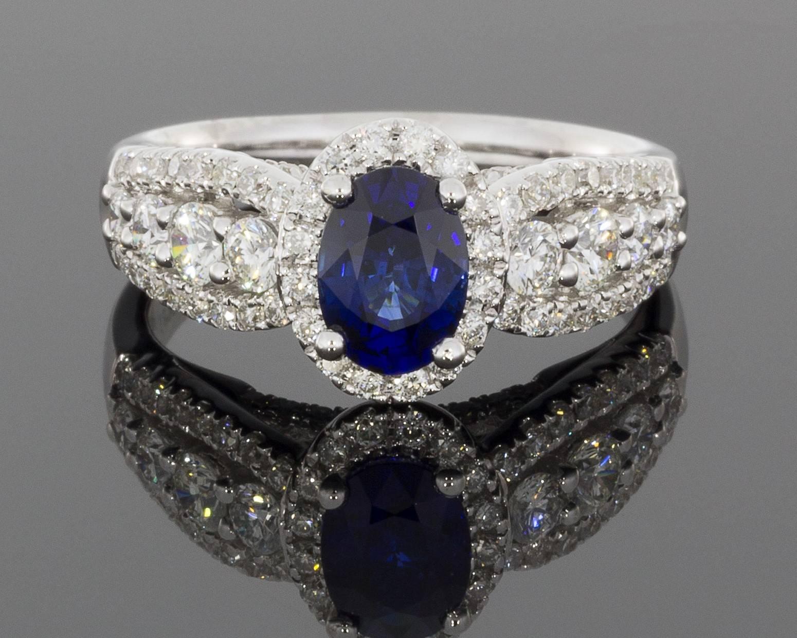 This breathtaking ring features a beautiful, 1.10 carat, natural, oval cut, blue sapphire. This gorgeous sapphire has exceptionally beautiful blue color that can hardly be captured by pictures. It is prong set in an 18 karat white gold halo ring.