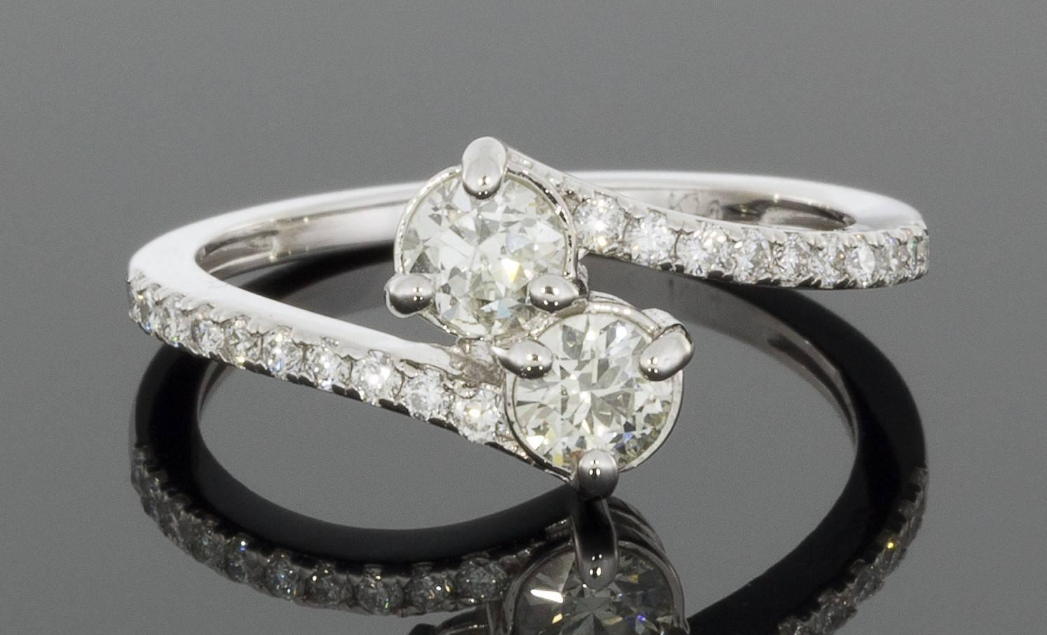 This beautiful bypass design diamond engagement ring features 2 main round brilliant center diamonds: one for you & one for your sweetheart. The center diamonds have a combined total weight of .50 carat & grade as K/VS1 in quality. The