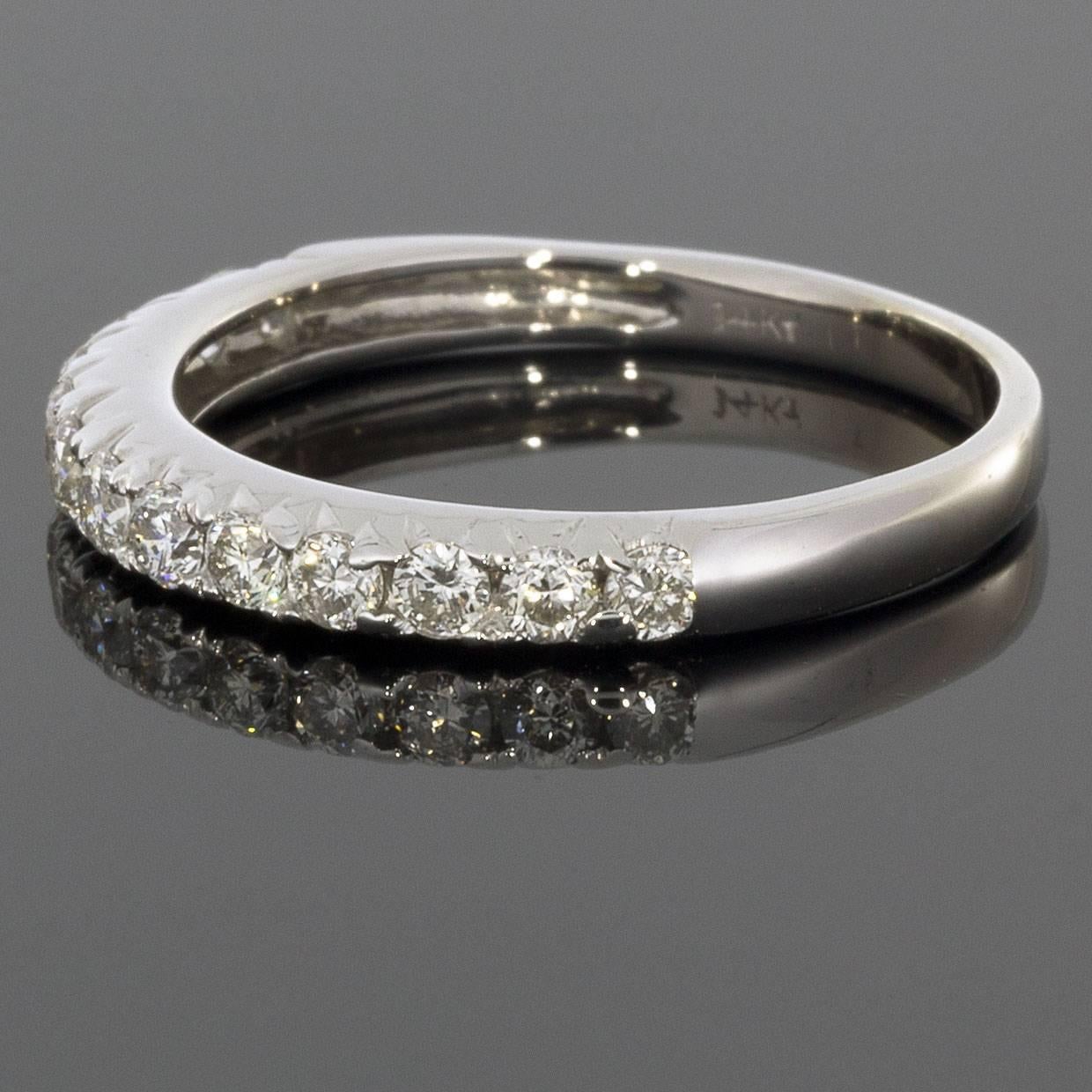 This classic band is a beautiful 14 karat white gold round diamond band that can dress up any ring. It can be used as a wedding band, stand alone band, or stack ring. The ring has 13 round cut diamonds that have a combined total weight of .42 carat.