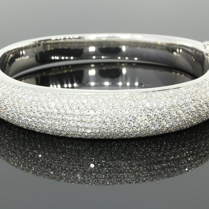 This sparkly & beautiful bangle bracelet features multiple rows of round brilliant cut diamonds weighing 5.60 carats total weight. The diamonds are G in color and VS2 in clarity. The diamonds are pave set across the top one-third of a domed style,