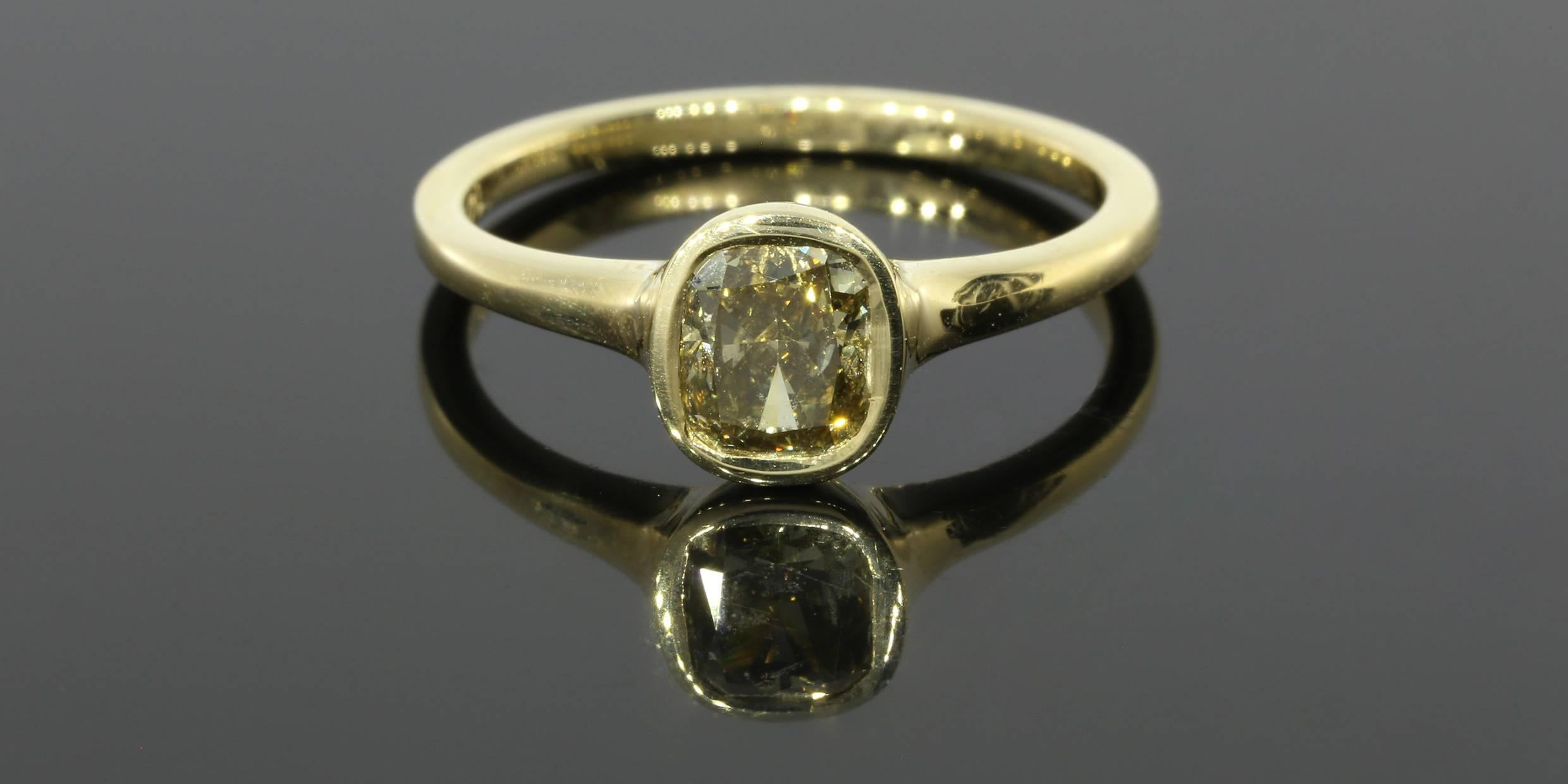 The ring features one cushion cut diamond weighing 1.01 carats. The diamond is certified through the Gemological Institute of America and has a lab report, number 5172319227. The diamond is graded as a dark brown/green/yellow in color and SI2 in