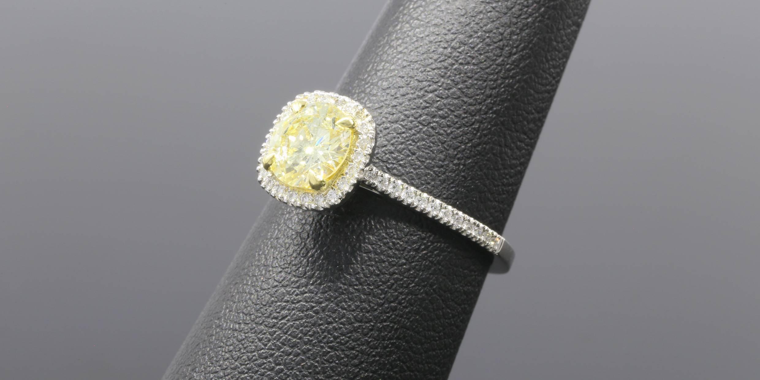 The ring features one round brilliant cut fancy yellow light diamond weighing 1.10 carats. The diamond has a lab report from the Gemological Institute of America and bears the report number 6177292103. The diamond is rated as an I1 in clarity, but