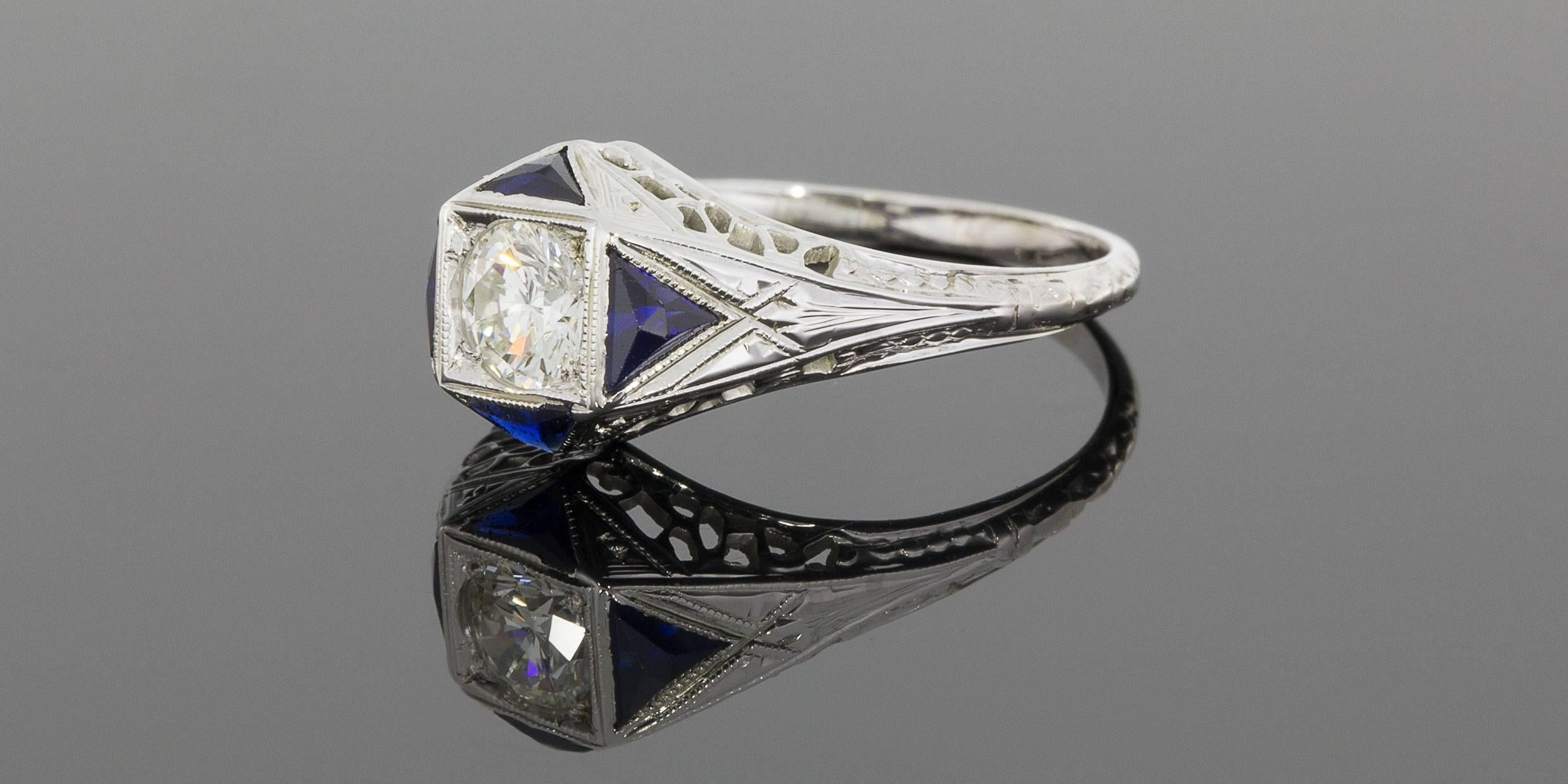 This beautiful, vintage ring features a 1/2 carat, round brilliant center diamond that is a G/VS2 in quality. This sparkling diamond is set in a milgrain accented, square shape in an 18 karat white gold ring. Pointing out from the square shaped
