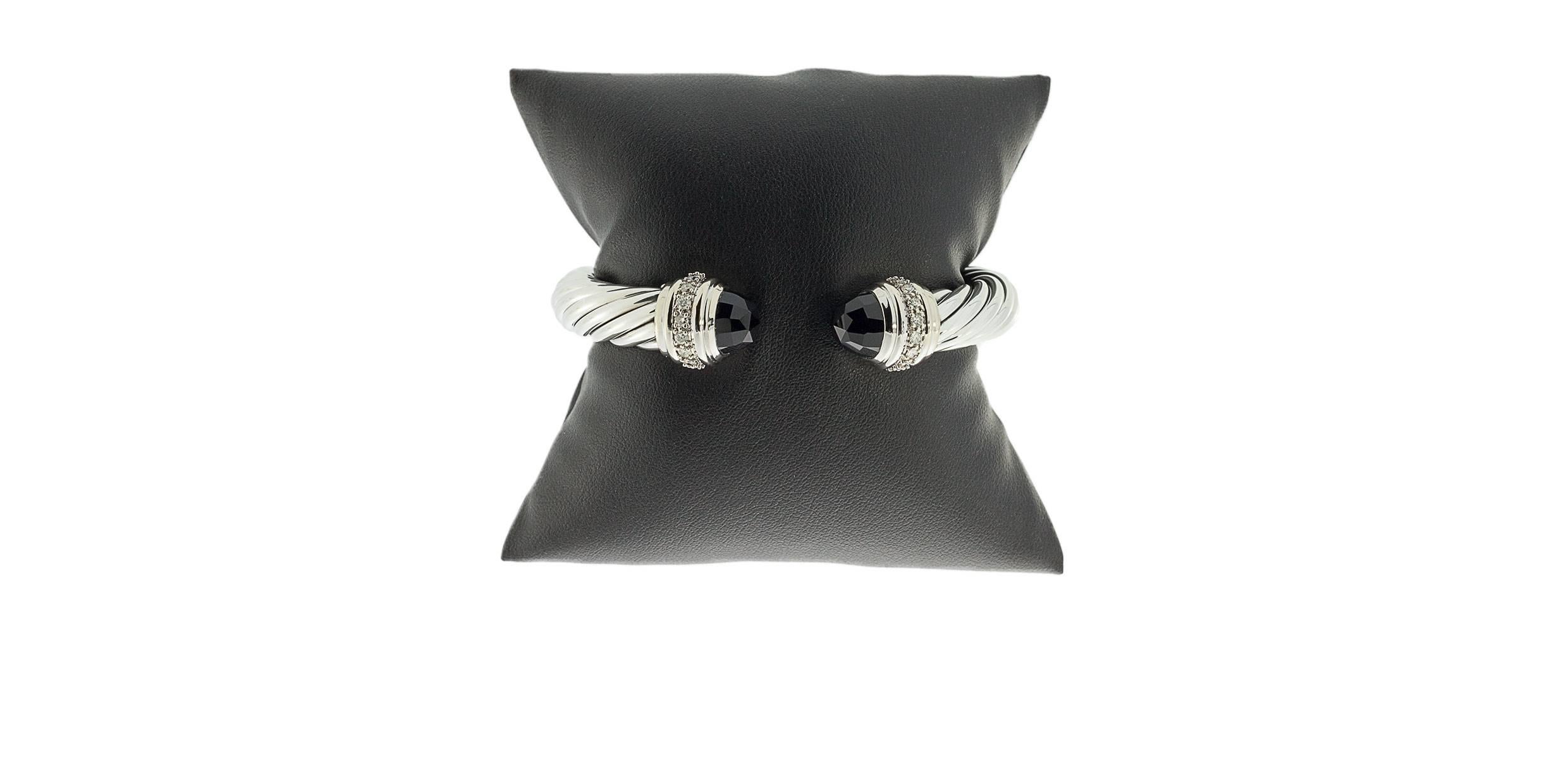 David Yurman's cable style jewelry has become his signature, the unifying element of every collection. This beautiful cuff bracelet features Yurman's iconic cable design in a 10mm width in sterling silver. The ends are capped with faceted black onyx