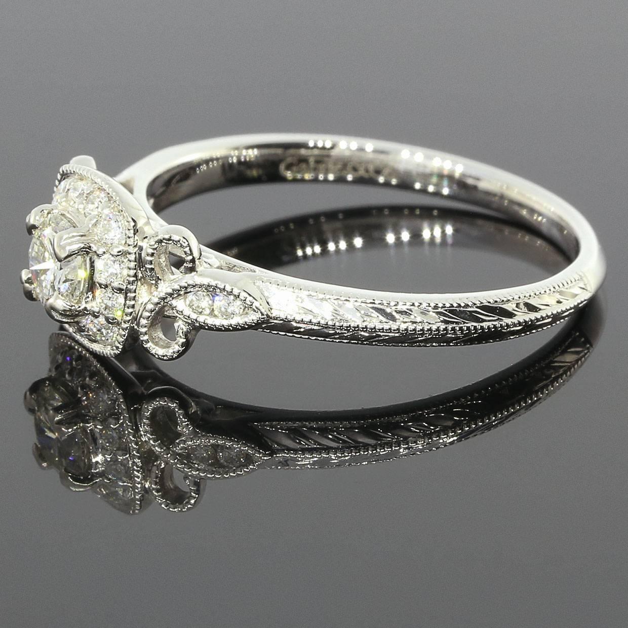 This beautiful ring features .38 carat of sparkly, round brilliant diamonds. The center diamond is a .26 carat round brilliant diamond that grades as I/SI1 in quality. This scintillating diamond is prong set in a cushion shaped, diamond halo with