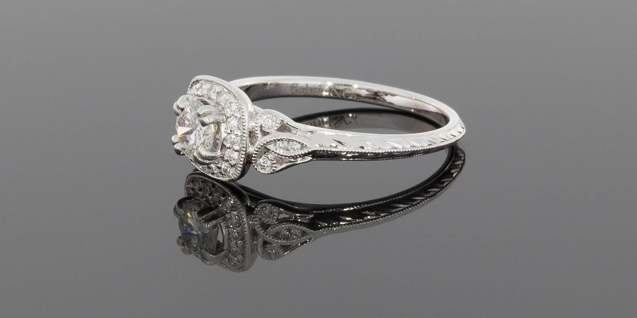 This beautiful ring features .47 carat of sparkly, round brilliant diamonds. The center diamond is a .33 carat round brilliant diamond that grades as G/SI2 in quality. This scintillating diamond is prong set in a cushion shaped, diamond halo with