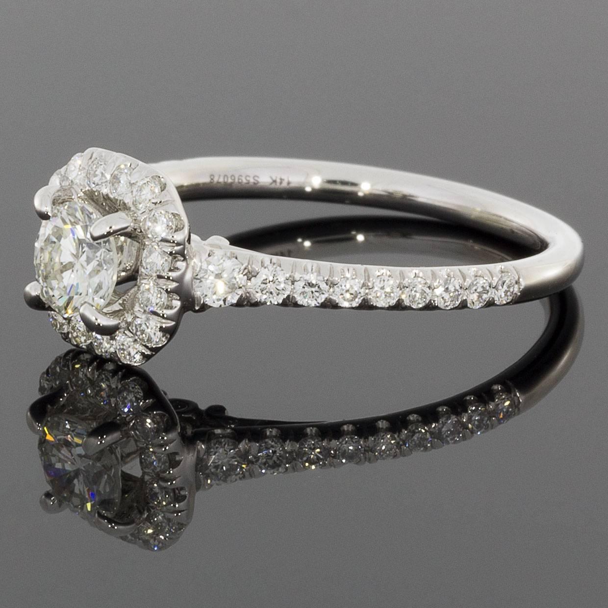 This lovely engagement ring has a classic cushion halo design. The ring features a round brilliant cut diamond center that weighs .38 carat & grades as H/SI1 in quality. This glistening diamond is surrounded by a cushion shaped halo of split