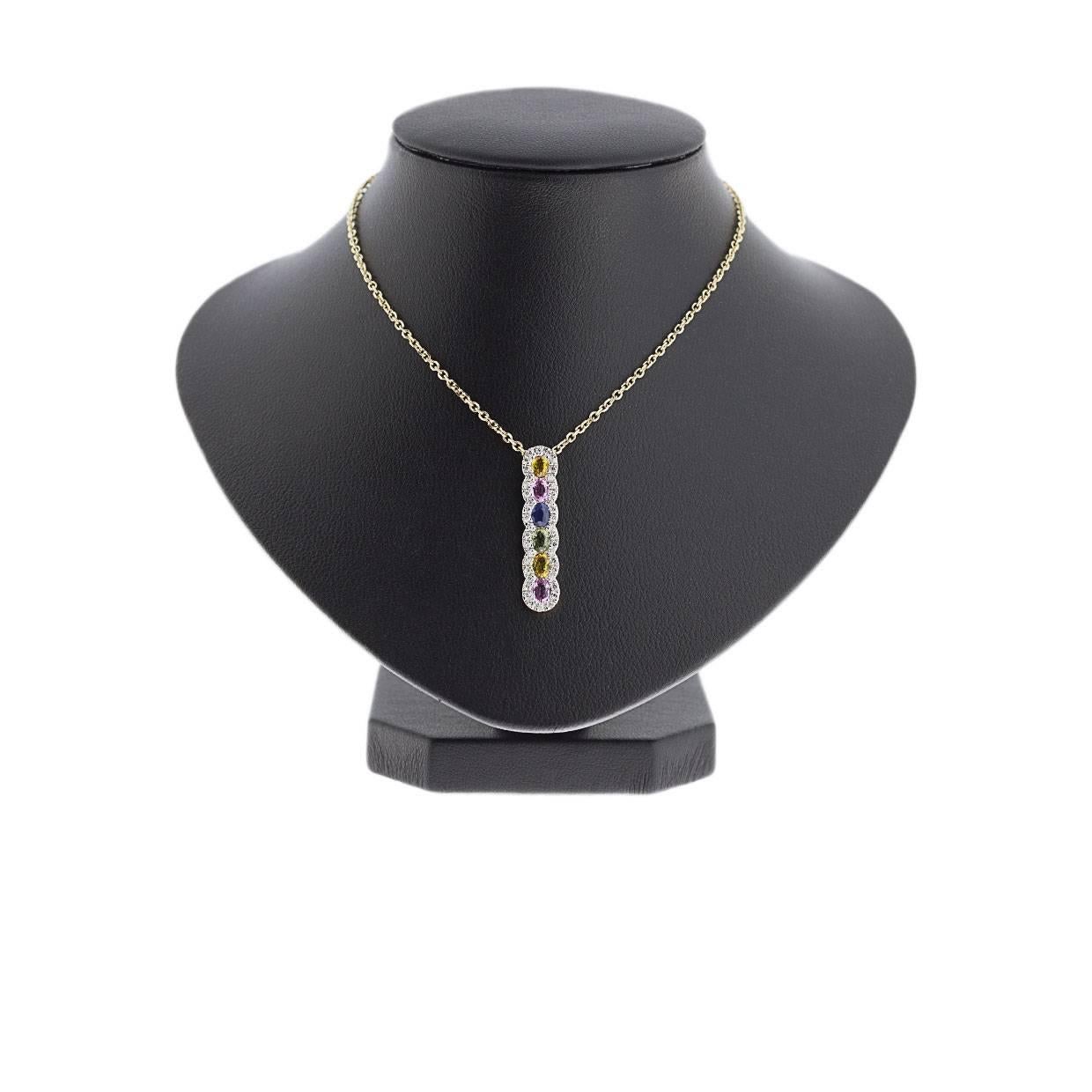 This unique pendant is full of color & sparkle! It is simple yet elegant & beautiful. It features 6 natural, oval cut sapphires: 2 yellow, 2 pink, 1 blue, & 1 green. These multicolor sapphires are bezel set with diamond halos partially surrounding