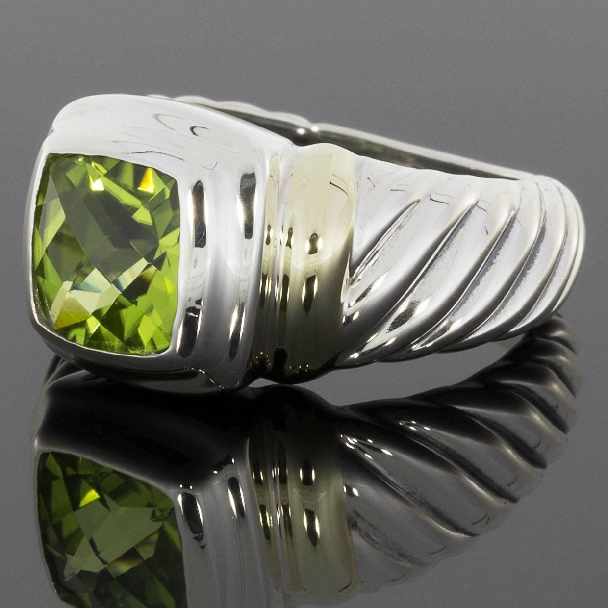 This beautiful David Yurman ring is from the Noblesse Collection. It features a square cushion cut peridot that is bezel set. The ring is comprised of sterling silver with 14 karat yellow gold accents. The shank features Yurman's signature cable