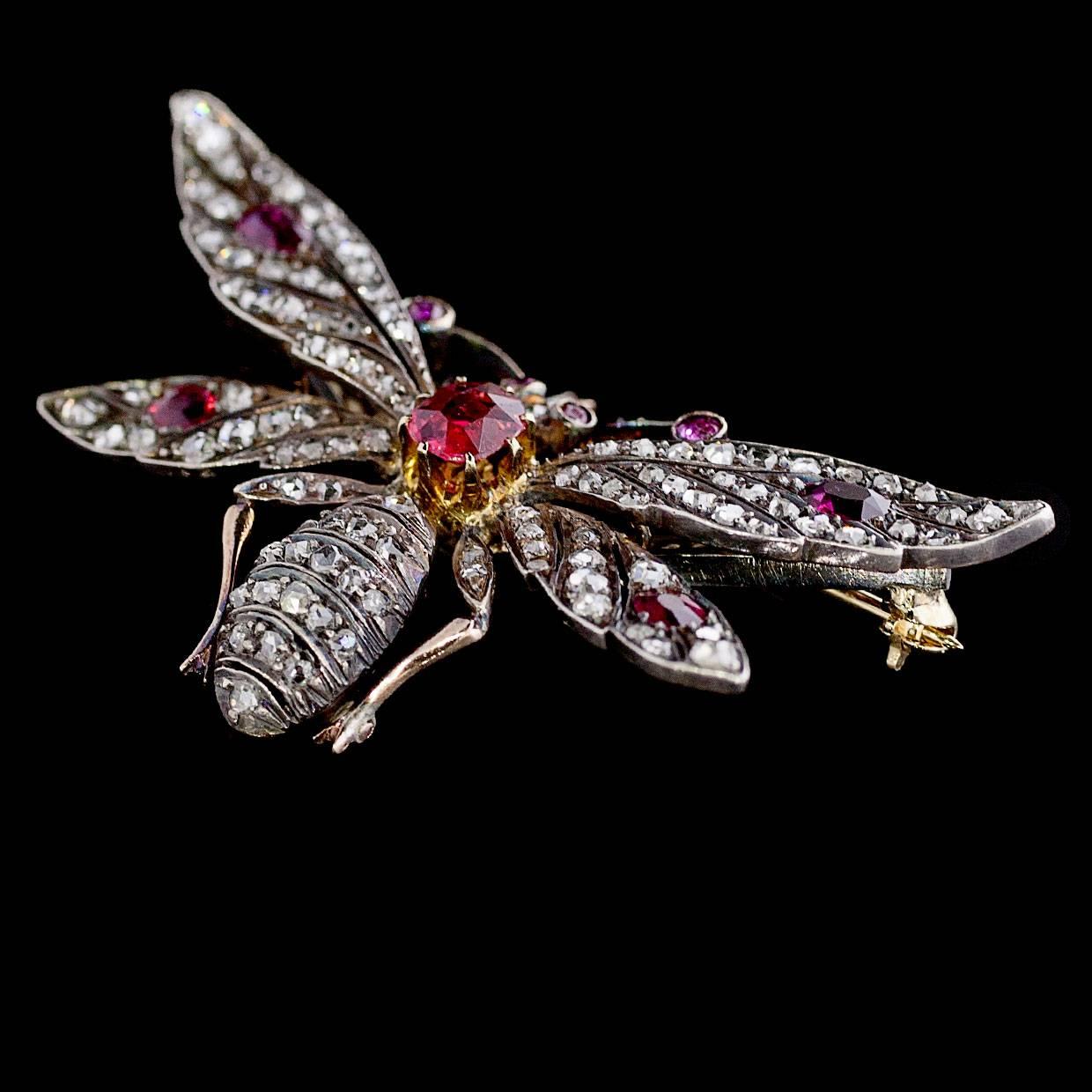 Add a little sting & sparkle to your look with this beautiful, unique antique ruby & diamond brooch! It features an over 1 carat, oval cut ruby with luscious red color that is prong set in yellow gold in the center of the bee. The antennae, wings,