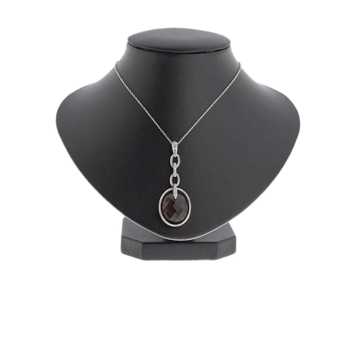 Simple yet elegant & beautiful would be the best way to describe this stunning pendant! It features a 14 x 12 millimeter, double sided, checkerboard faceted, oval smoky quartz. This lovely smoky quartz is suspended in the center of a white gold