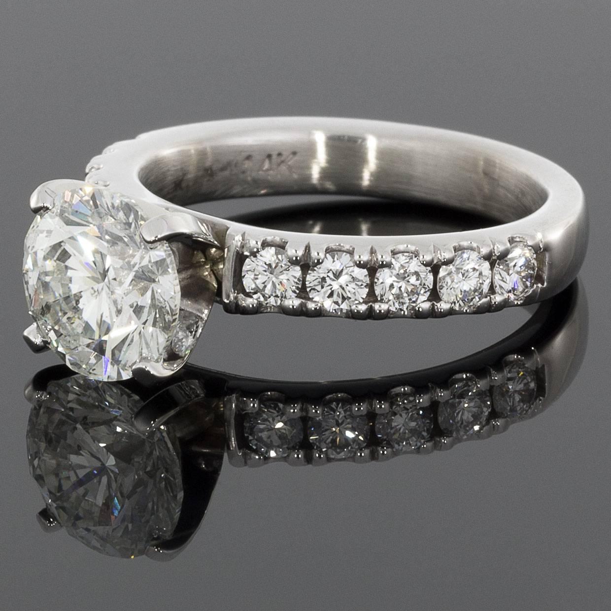 This lovely, classically styled engagement ring makes a stunning statement. Prominently & elegantly showcased in a 4 prong setting, the center diamond is a beautiful 2.19 carat round brilliant cut diamond that is GIA certified as H/I1 in