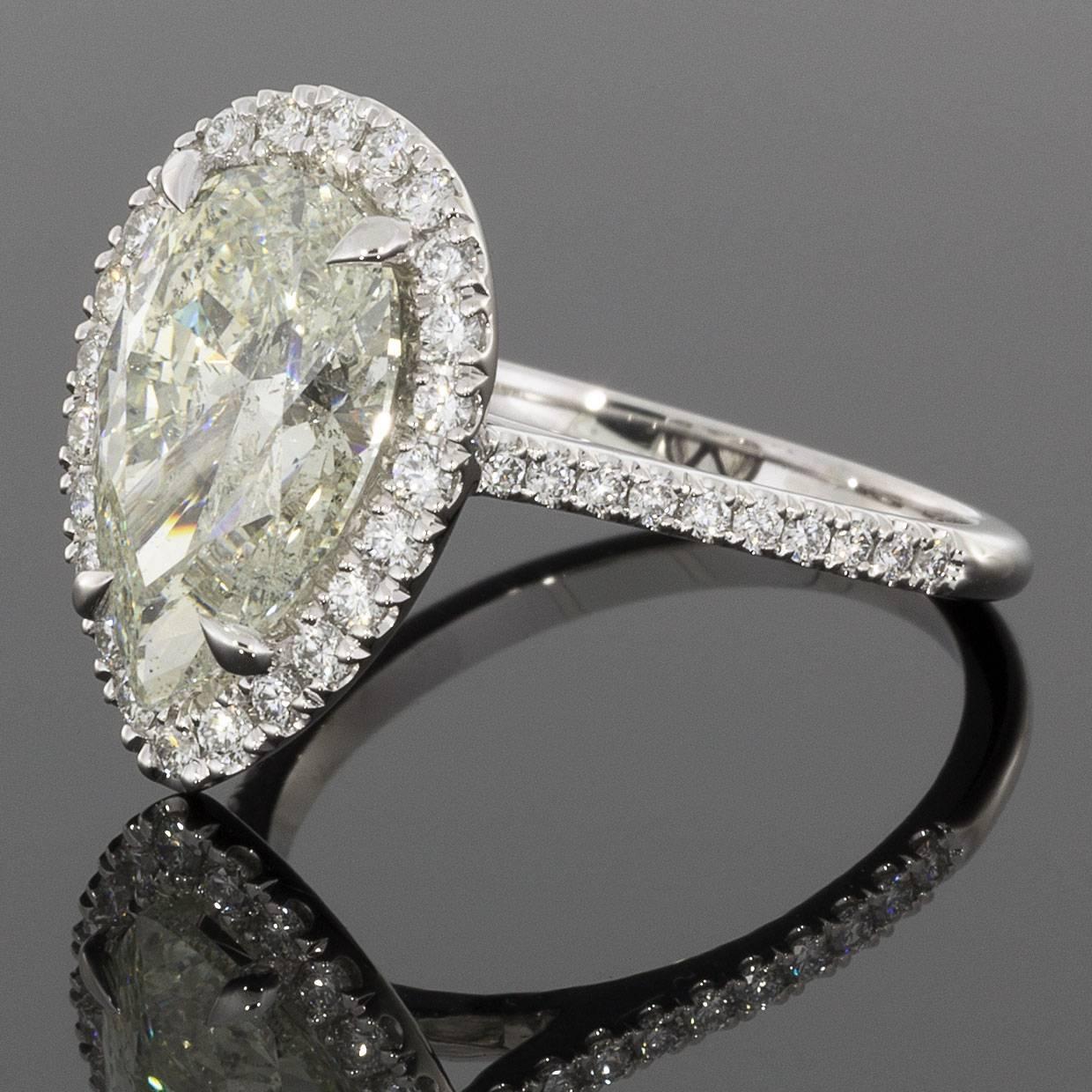 This absolutely stunning diamond halo ring will surely take your breath away! The custom made setting was designed to showcase its beautiful 3.23 carat pear brilliant center diamond. This diamond is EGL certified to be J/SI3 in quality. It is prong