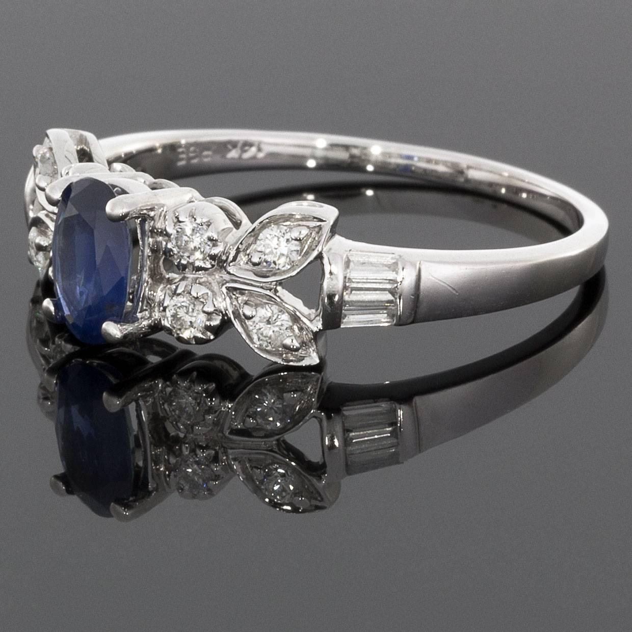 This luscious sapphire ring has a beautiful butterfly design that gives a really unique & elegant look. The ring features an oval cut, natural, blue sapphire center. The ring's shoulders are accented with round brilliant cut diamonds that are