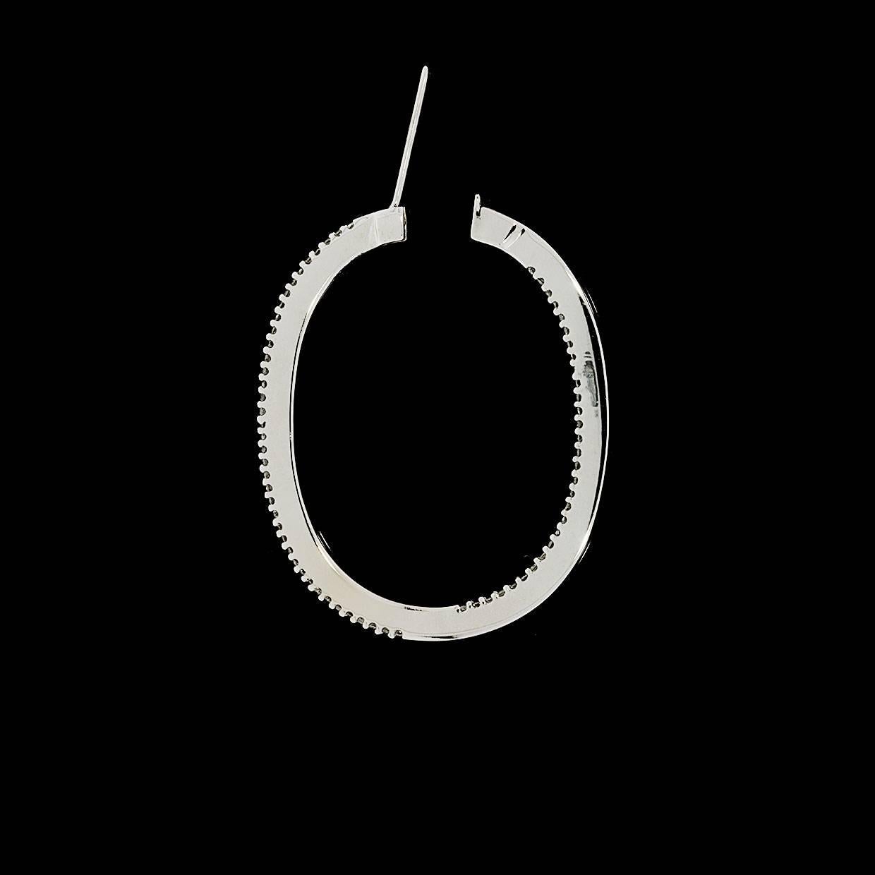 These timeless, versatile earrings have a total weight of 1 carat. Beautiful round brilliant diamonds are shared prong set in 14 karat white gold, oval shaped, inside out style hoop earrings. The diamonds are HIJ/SI2-I1 in quality. The earrings
