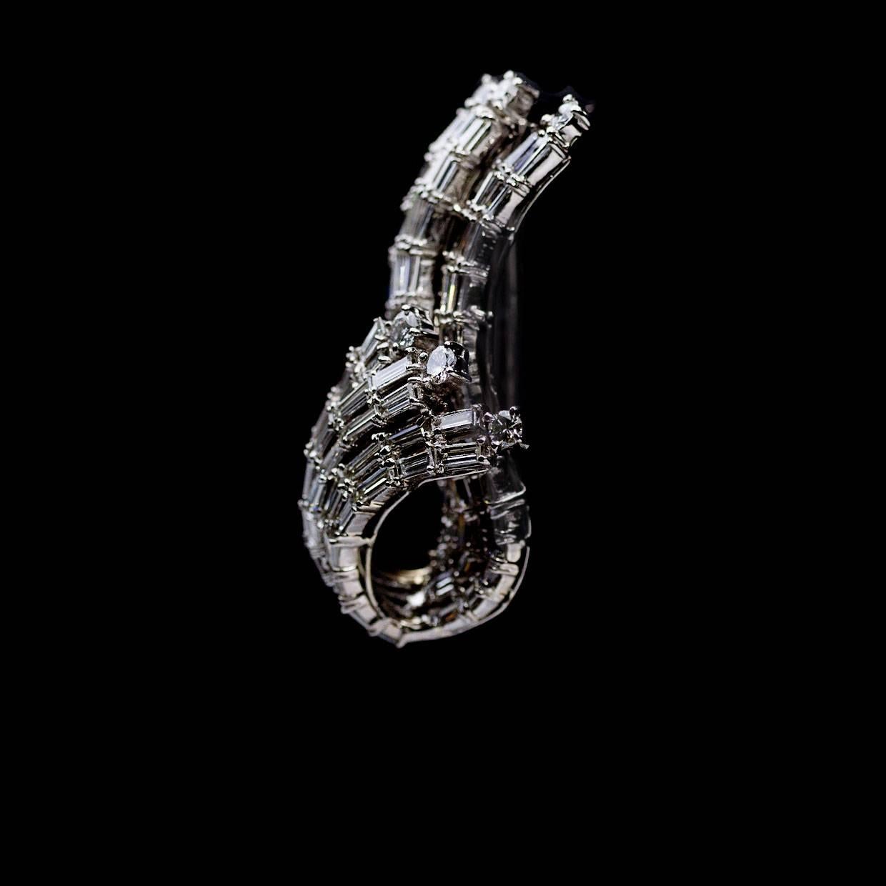 This incredible brooch features approximately 10.58 carats total diamond weight. The diamonds are baguette and round cut and set in 18K white gold. The diamonds grade as VS-SI in quality and G in color. 

This unique brooch measures approximately 43