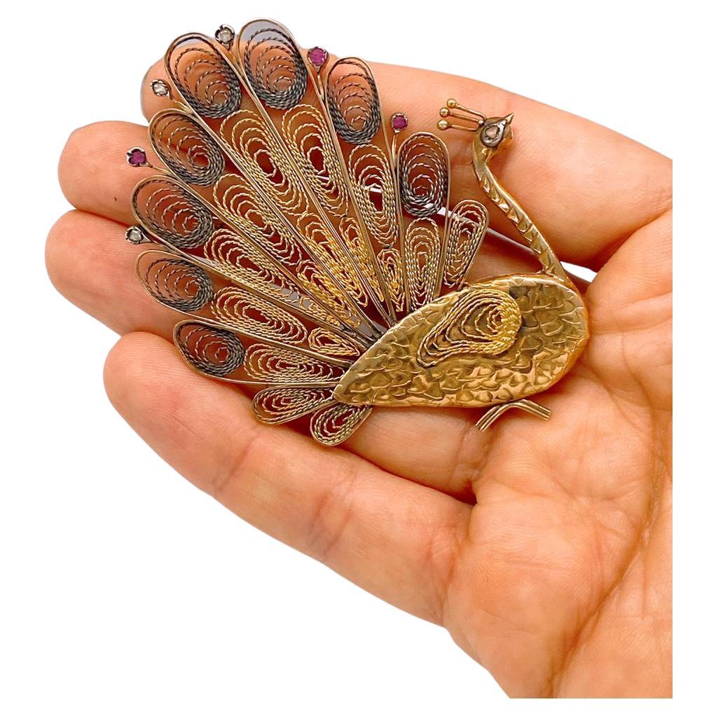 Antique Russian peacock brooch with magnificent wire jewelry technique decorted with rubies and rose cut diamonds with a total 14k gold weight of 16.50 grams hall marked 56 imperial Russian gold standard and initial maker mark dates back to the