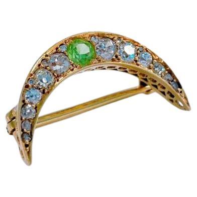 Antique Russian crescent brooch with old mine cut diamonds estimate weight of 1 carat centered with a demantoid stone brooch length is 2.5cm hall marked 56 imperial Russian gold standard and Moscow assay mark st George slaying the dragon before