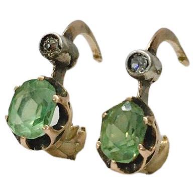 Antique Russian earrings centered with green demantoid stone with a diameter of 5.20mm×4mm in solitaire earrings style with small old mine cut diamond on top earrings length 1.5cm hall marked 56 imperial Russian gold standard and Moscow assay mark