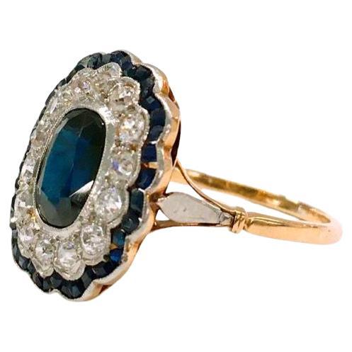 Antique sapphire and old mine  diamond ring centered with 1 natural midnight blue sapphire colour flanked with old mine cut diamonds estimate weight of 1 carat and smaller sapphires in baguette cut ring is 14k gold setting dates back to the