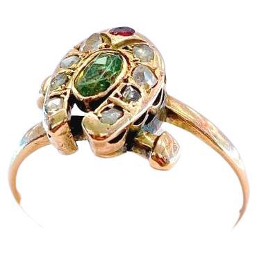 Antique russian ring in hourse shoe desige centeted with oval green demantoid flanked with smaller rose cut diamonds and 1 ruby stone ring dates back to imperial russian era 1904/1907.c hall marked 56 imperial russian gold standard and the coucase