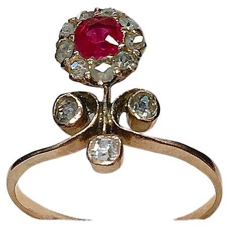 Antique 14k gold ring in unuswal flower designe centered with 1 natural ruby pegion blood colour with a diameter of 5mm flanked with rose cut diamonds hall marked 56 imperial russian gold standard and import mark 