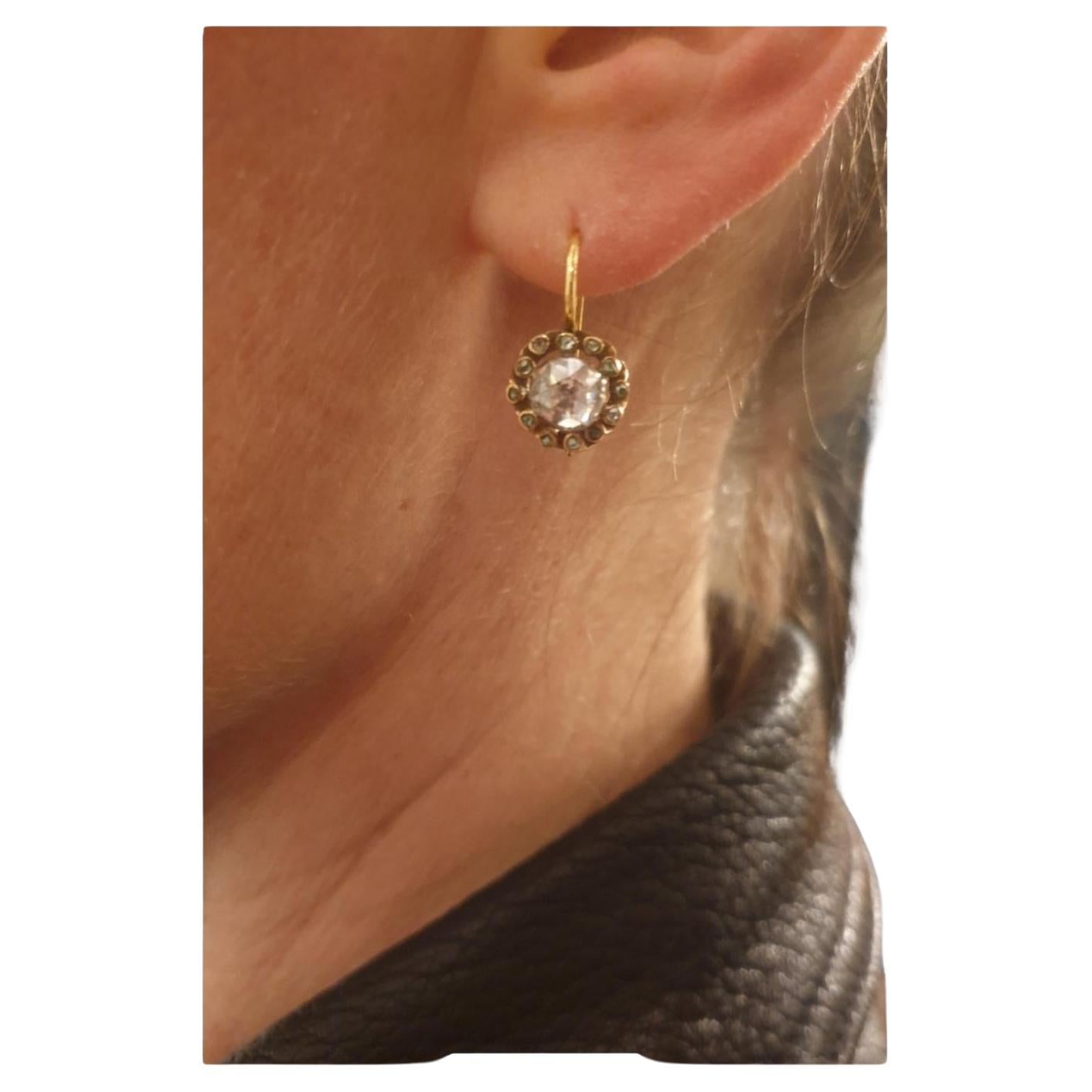 Antique 1880s Earrings in solitare style centered with rose cut diamond back foiled with a diameter of 7mm each full facets excellent spark flanked with smaller diaminds in yellow gold settings 