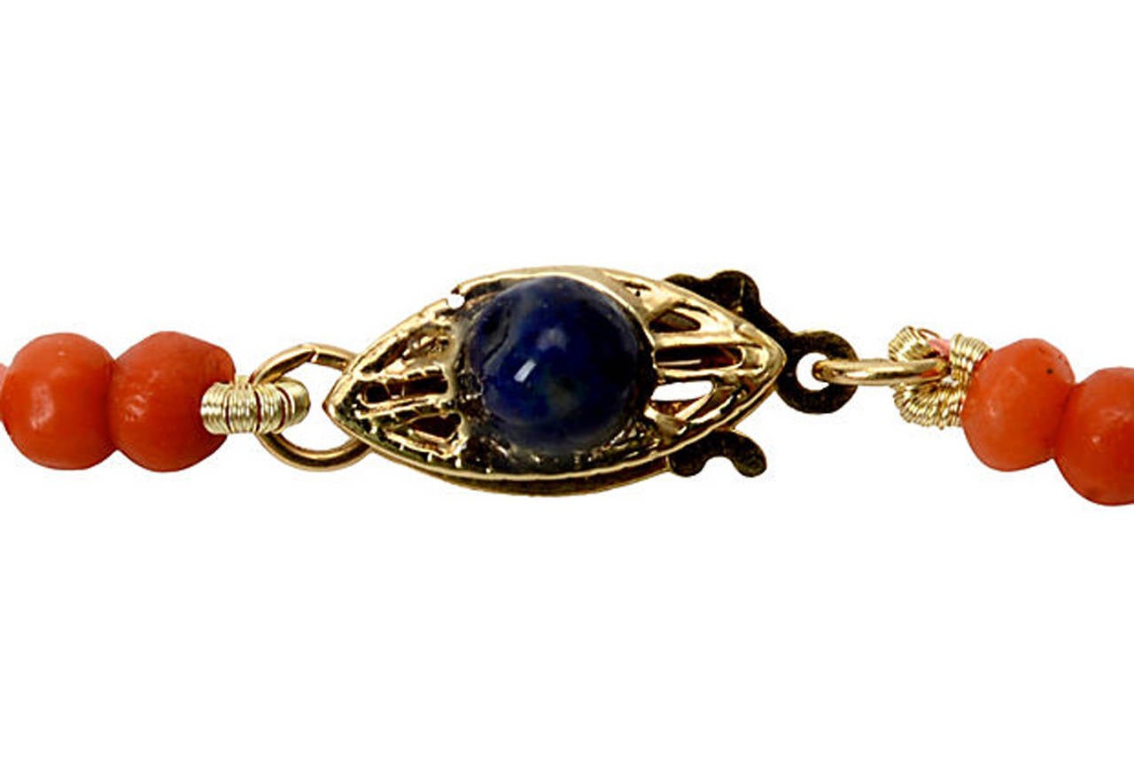 Coral, lapis and goldtone rondelle necklace with a 14kt gold clasp. Center Lapis bead measures 10.45mm others, 7mm, coral beads are 3mm.