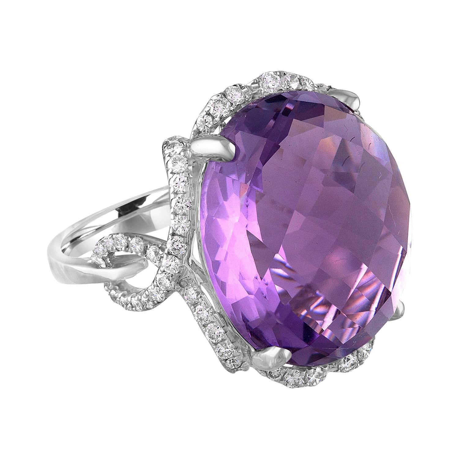 Fun Large Ring.
The ring is 18K White Gold.
There are 0.58 Carats in Diamonds G/H SI.
The Amethyst is 16.55 Carats Faceted Cabochon.
The top measures 0.75