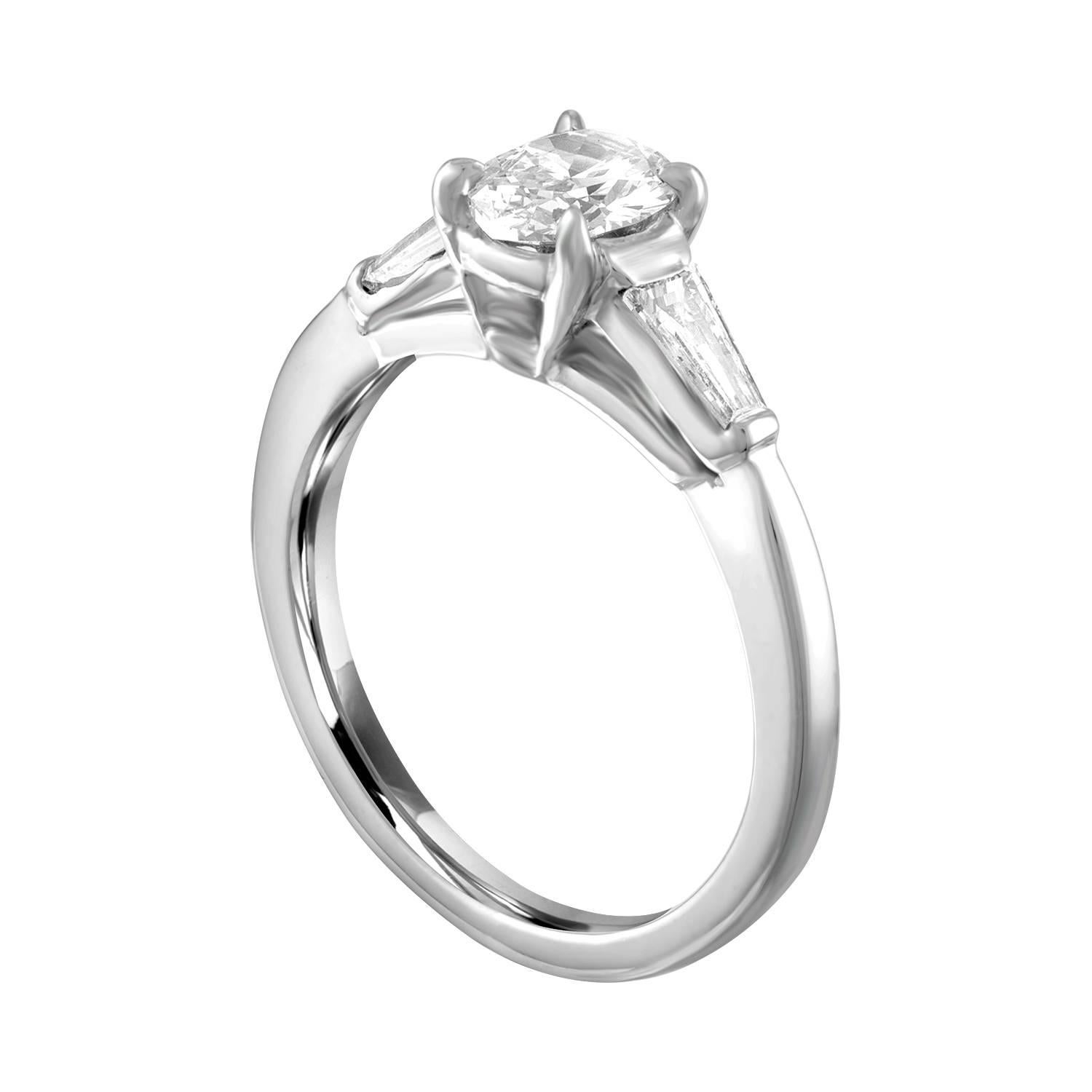 Bague de fiançailles de forme ovale.
La bague est en platine.
La pierre centrale est un ovale de 0,51 carats F VS.
Il y a 2 baguettes effilées de 0,50 carats F VS.
L'anneau est une taille 5.00, de bonne taille.
L'anneau pèse 3.9 grammes.