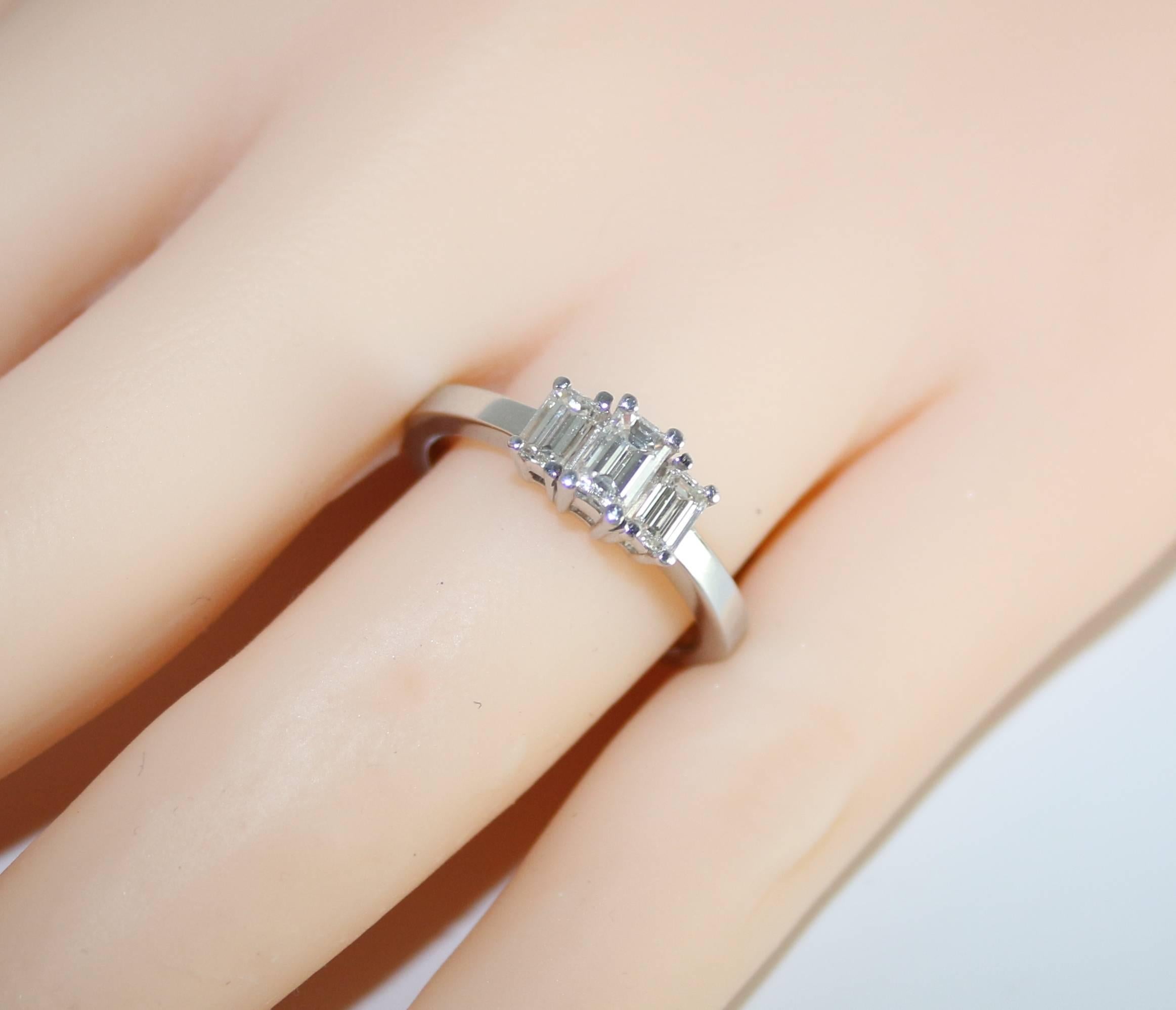 Contemporary 0.90 Carat Emerald Cut Diamond Three Stone Platinum Ring For Sale